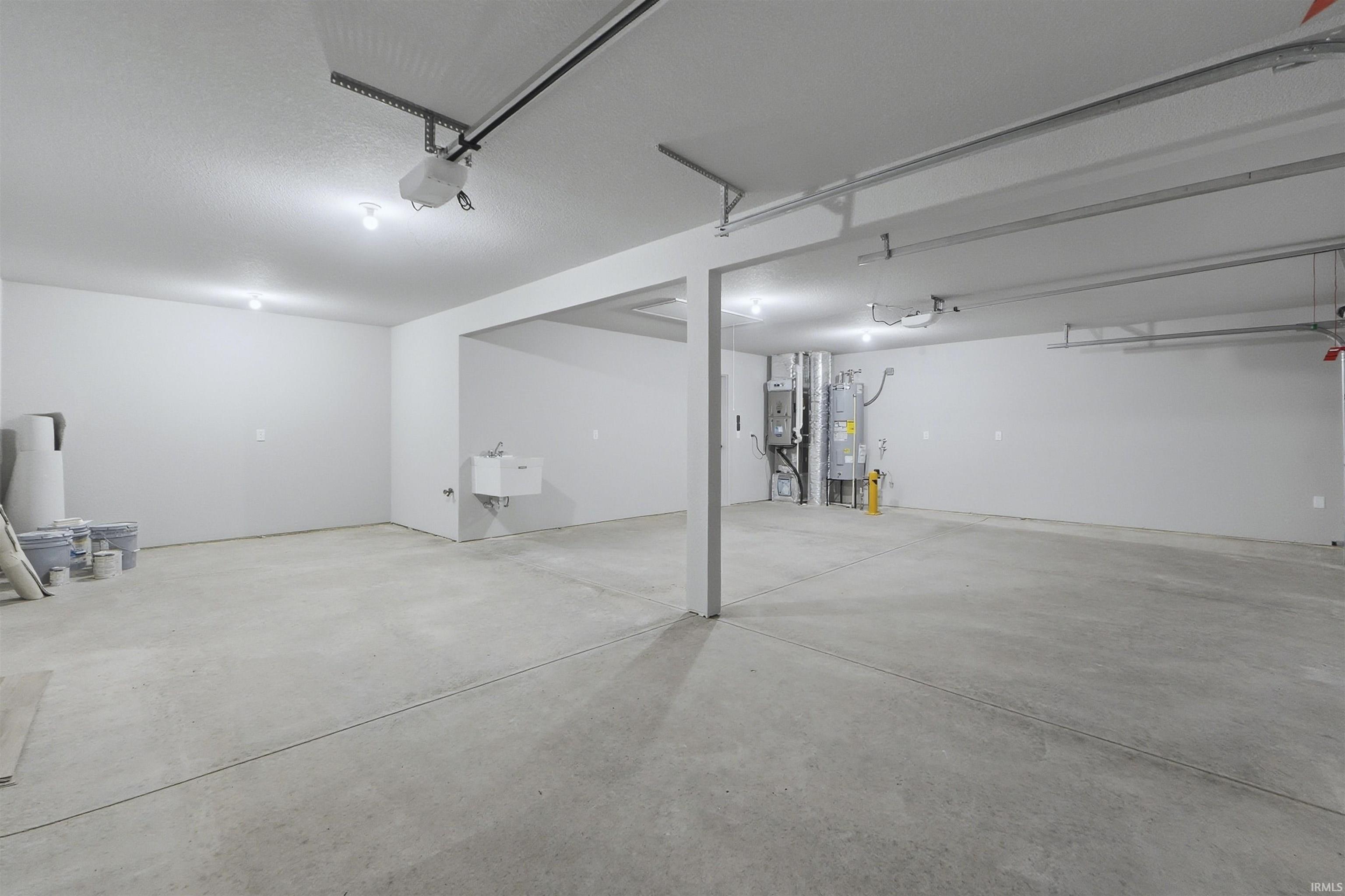 Garage featuring water heater and a garage door opener