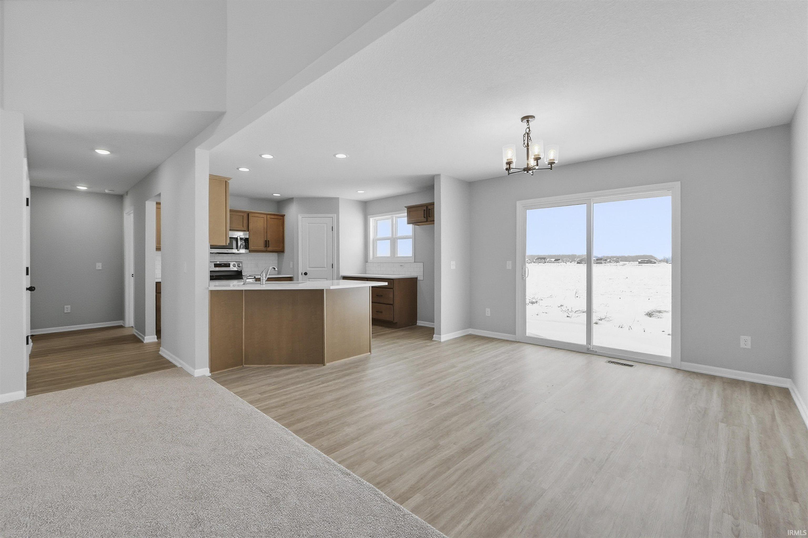 Kitchen featuring open floor plan, light countertops, a peninsula, and wood finish cabinets