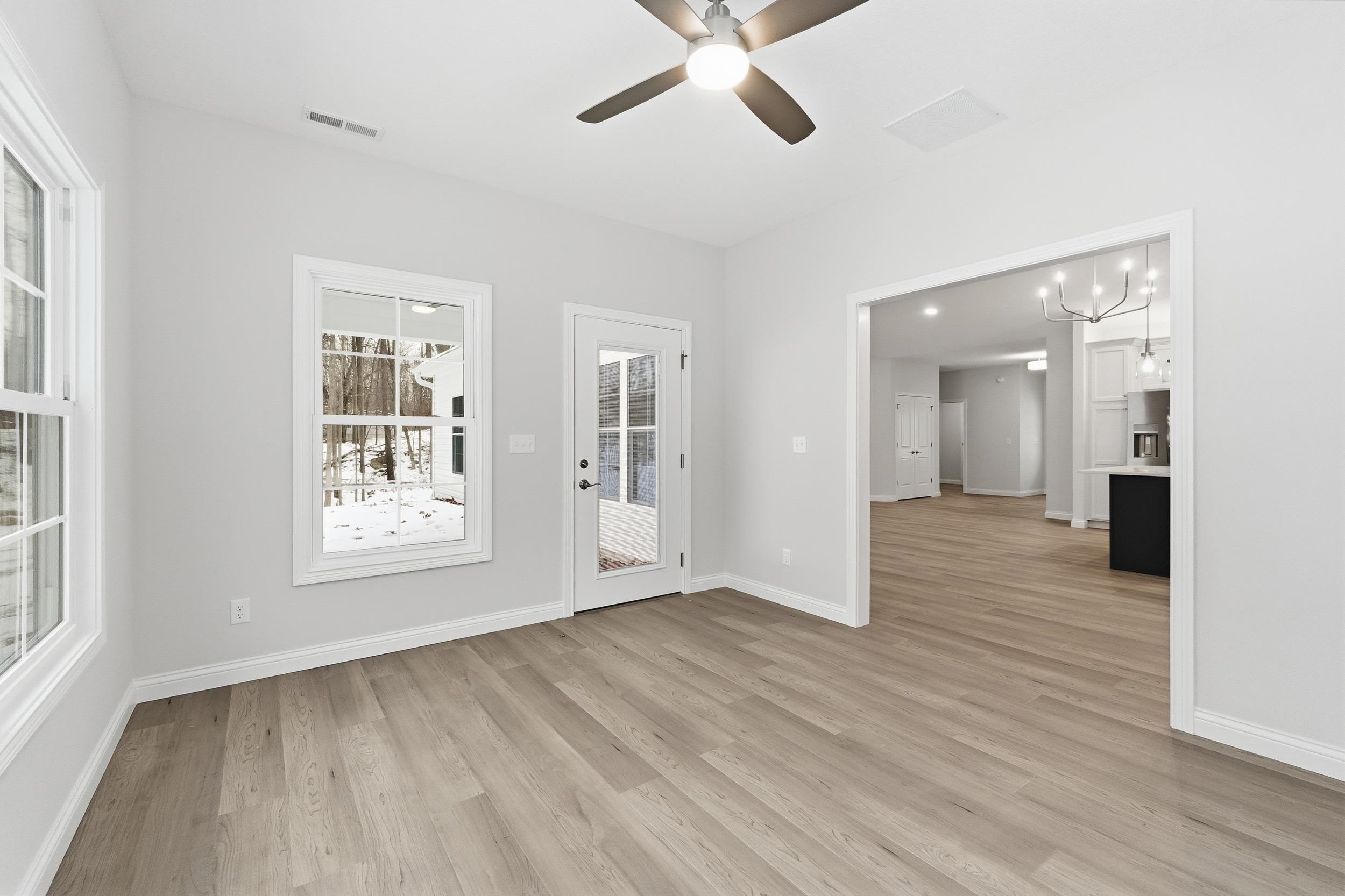 Unfurnished room with a chandelier, light wood-style floors, and ceiling fan
