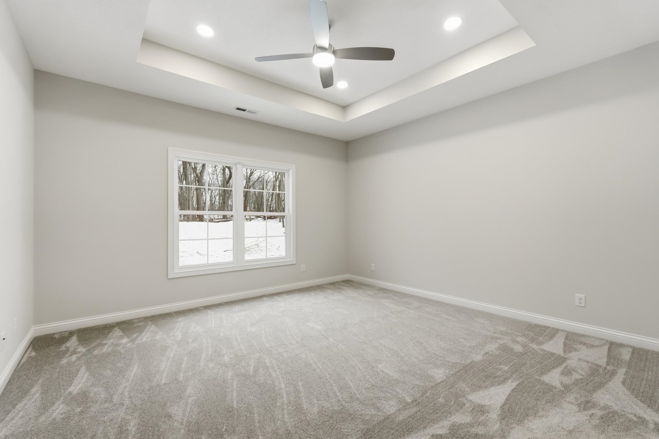 Unfurnished room with a tray ceiling, light carpet, recessed lighting, and a ceiling fan