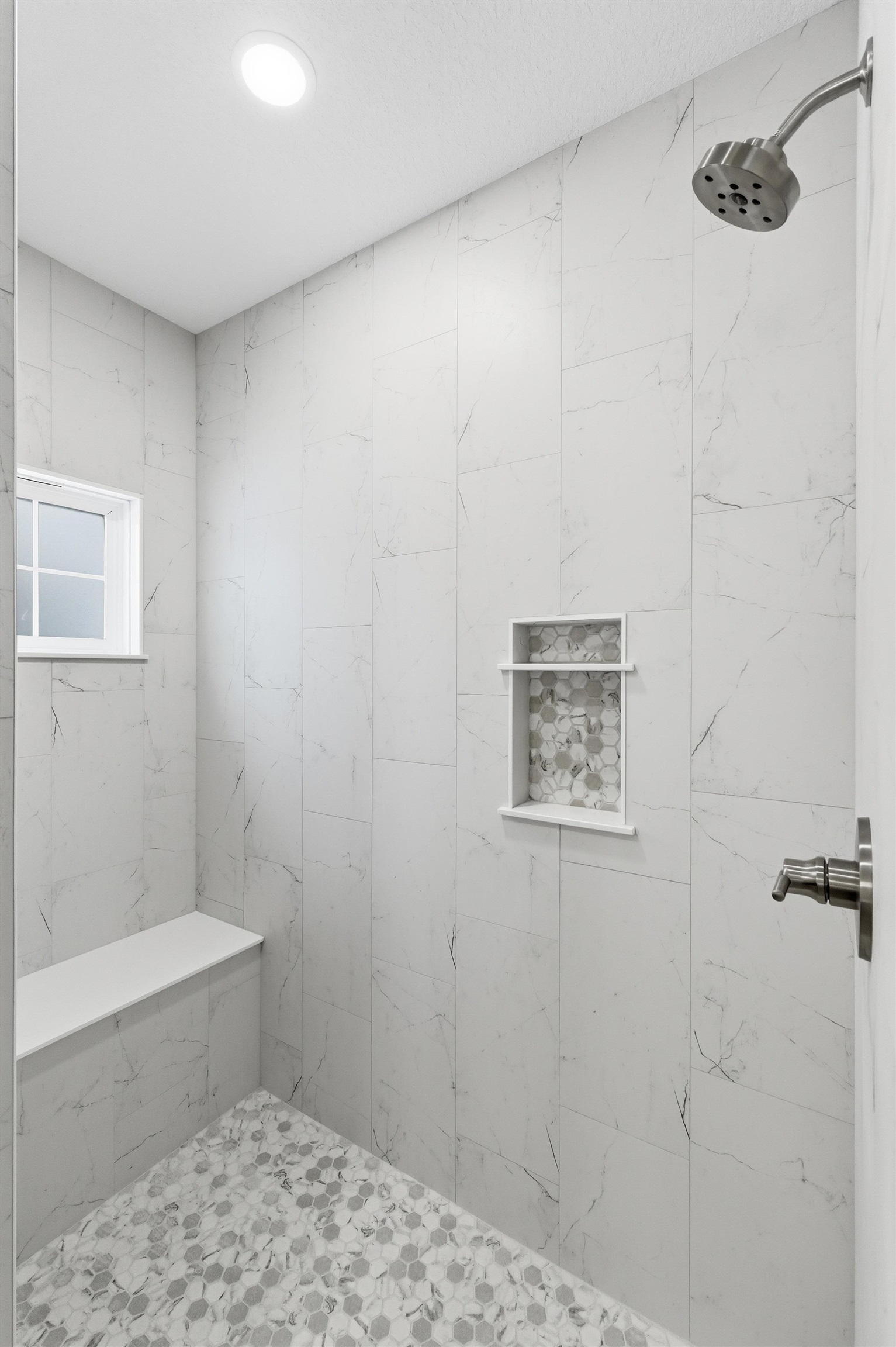 Full bath with a marble finish shower