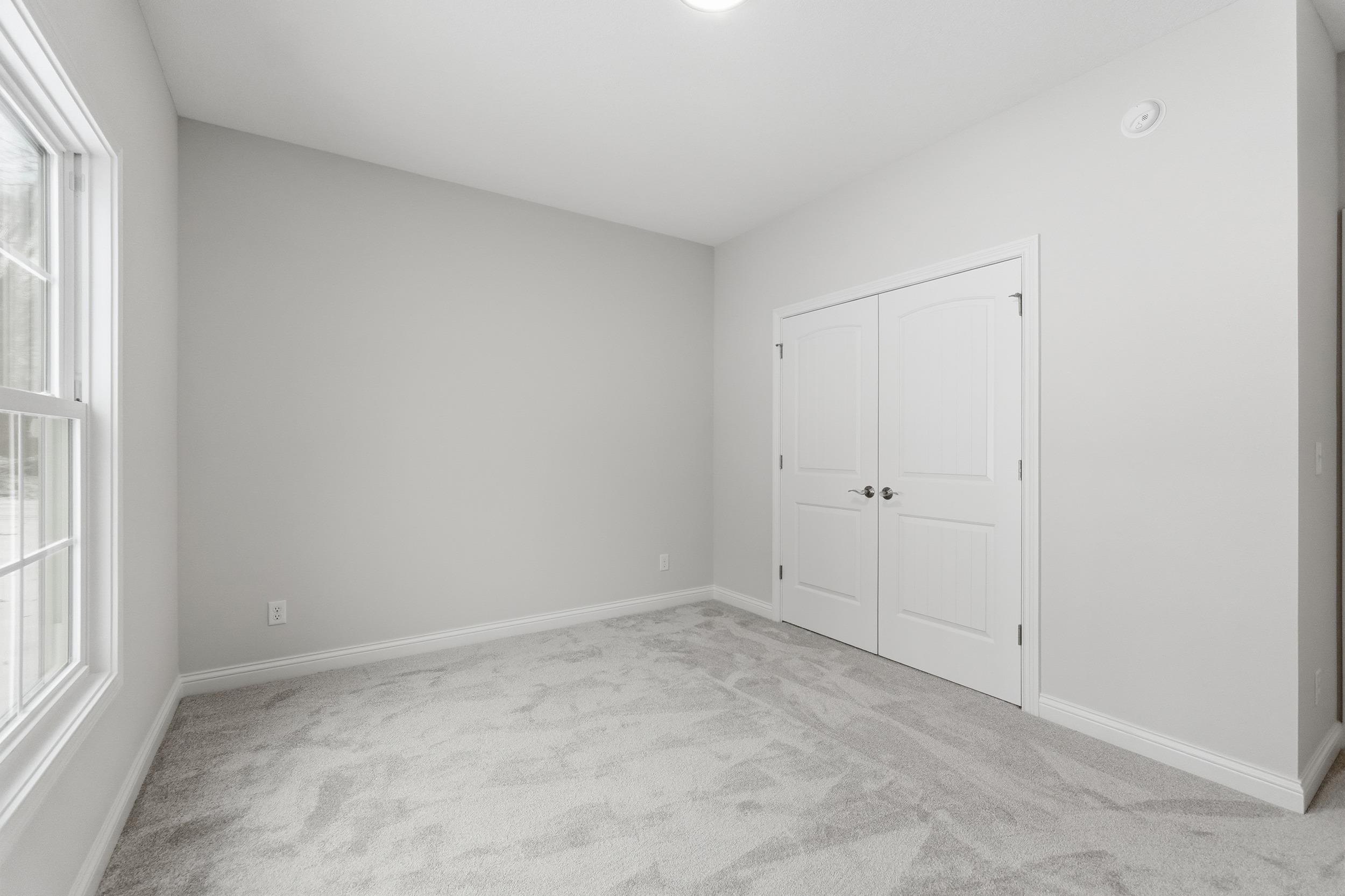 Unfurnished bedroom with light colored carpet and a closet