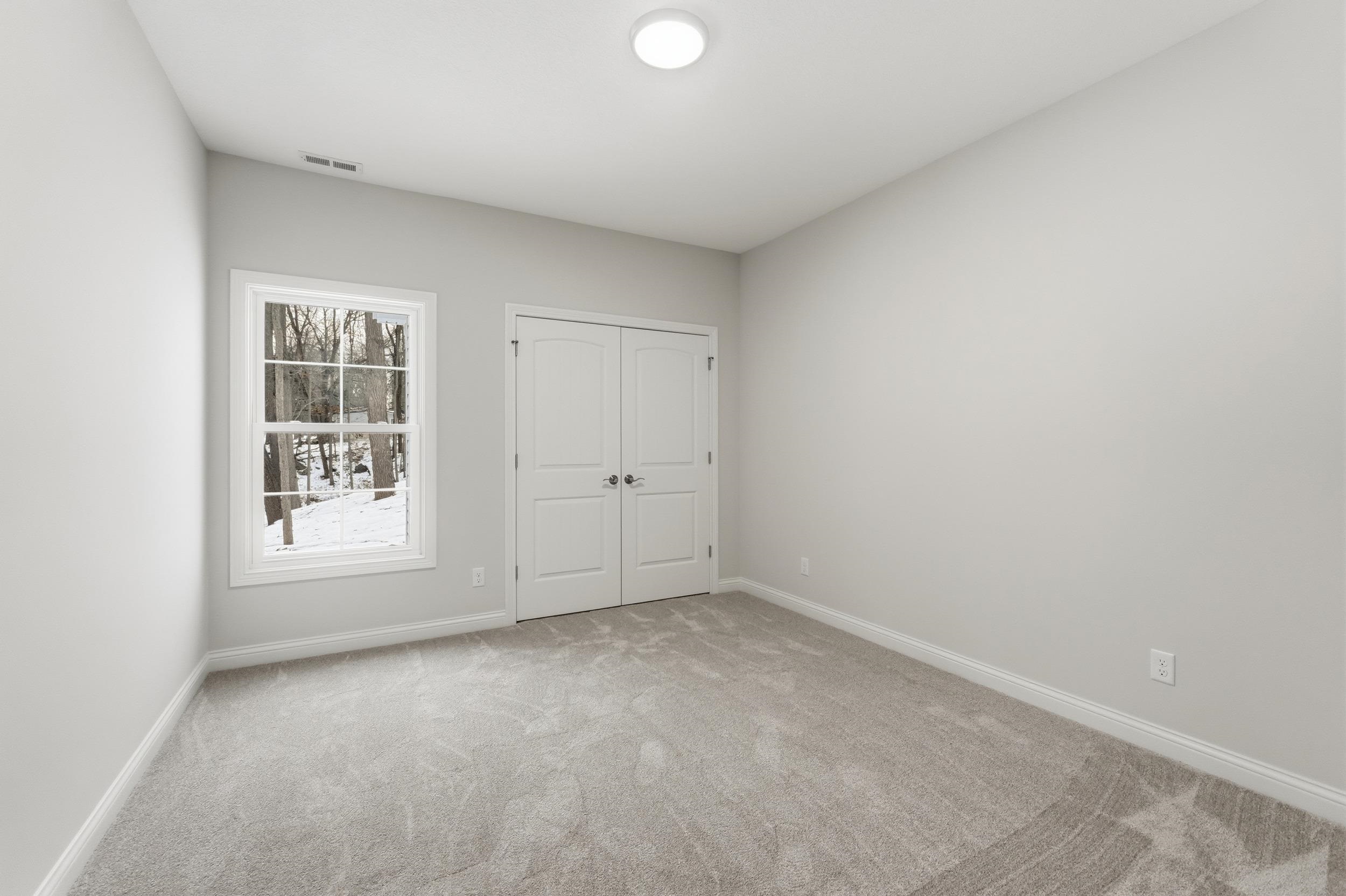 Unfurnished bedroom with light carpet and a closet