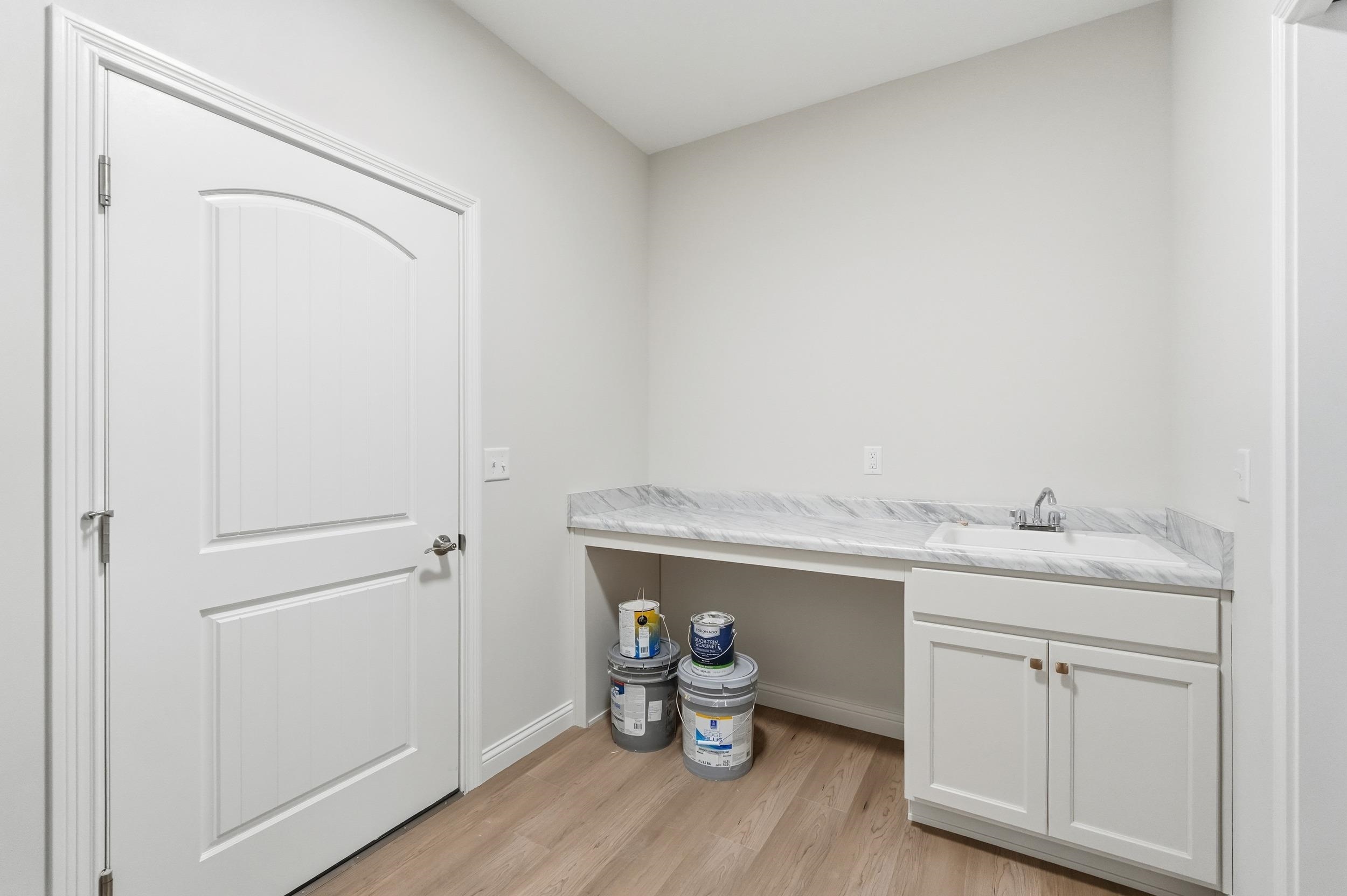 Laundry room with light wood-type flooring and baseboards