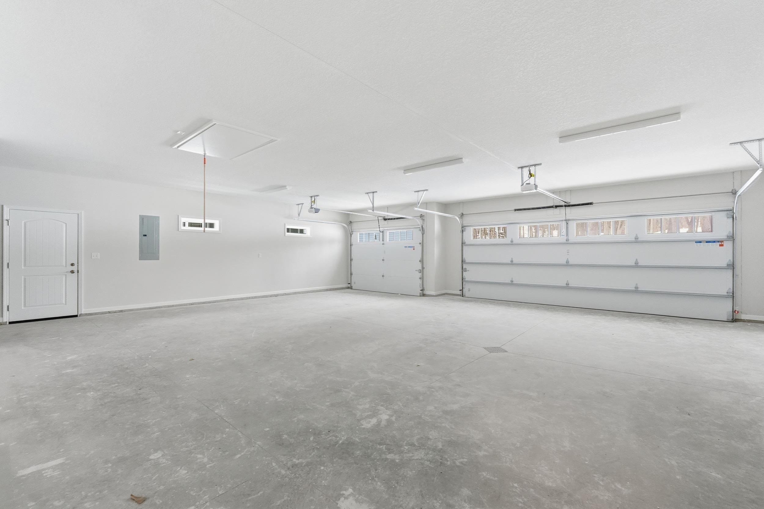 Garage with electric panel and baseboards