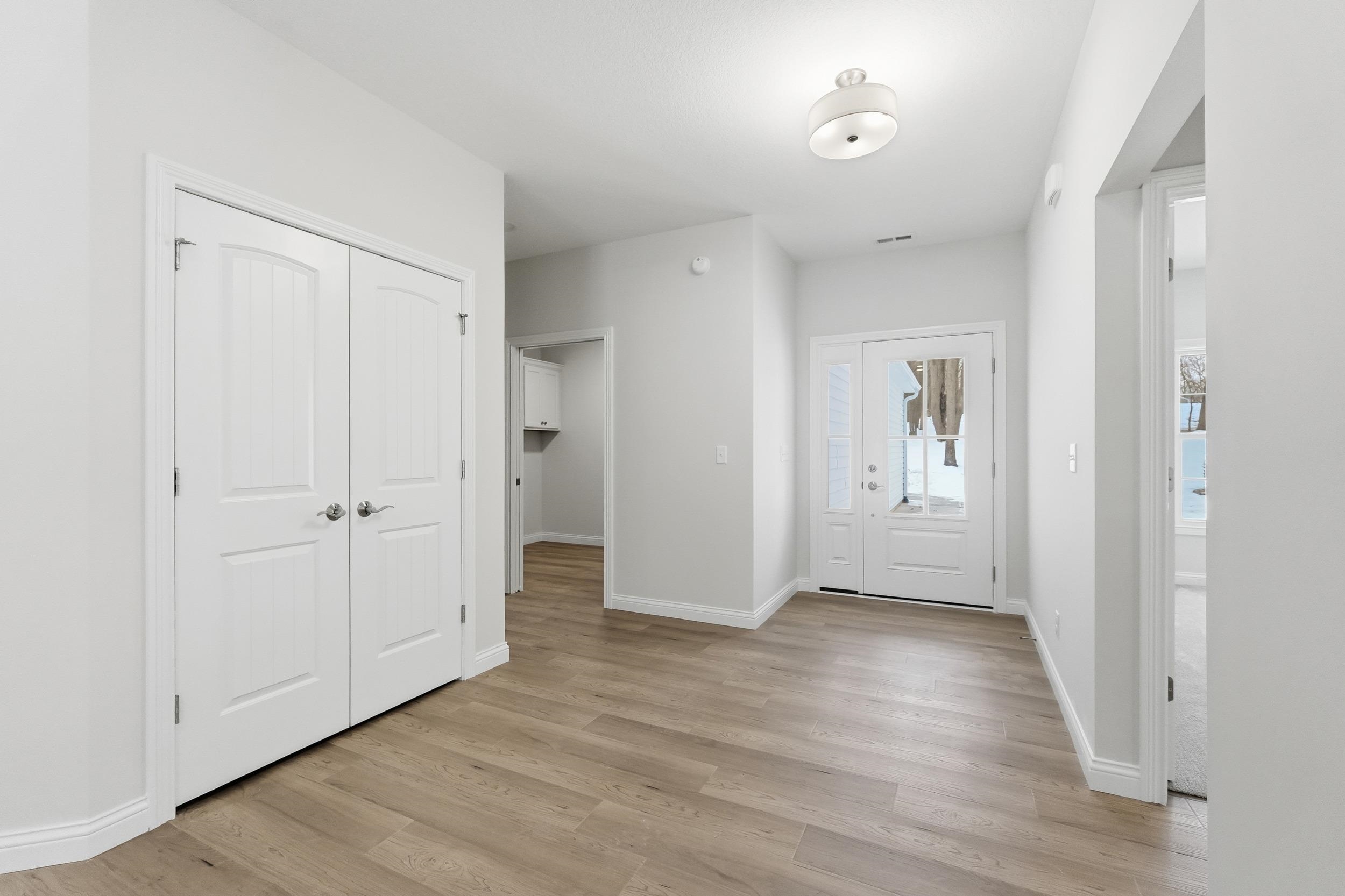 Foyer entrance featuring light wood-style flooring and baseboards
