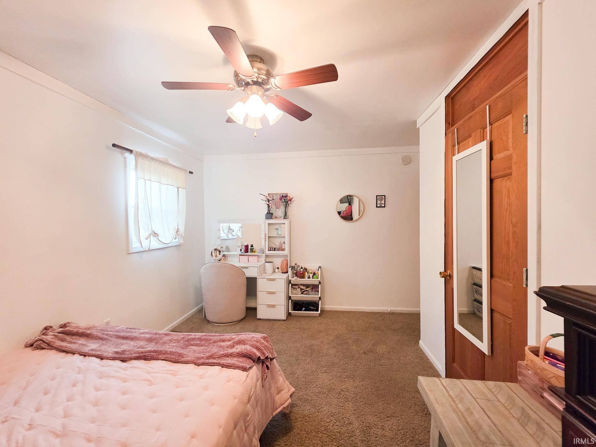 Bedroom featuring dark carpet and a ceiling fan