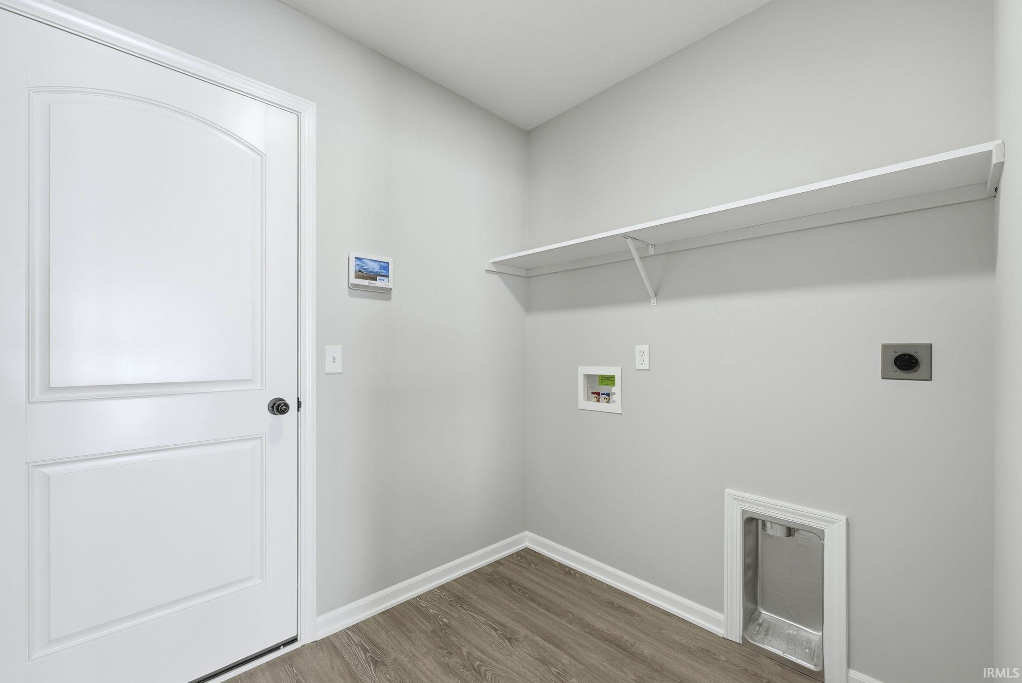 Laundry area with wood finished floors, hookup for a washing machine, and electric dryer hookup