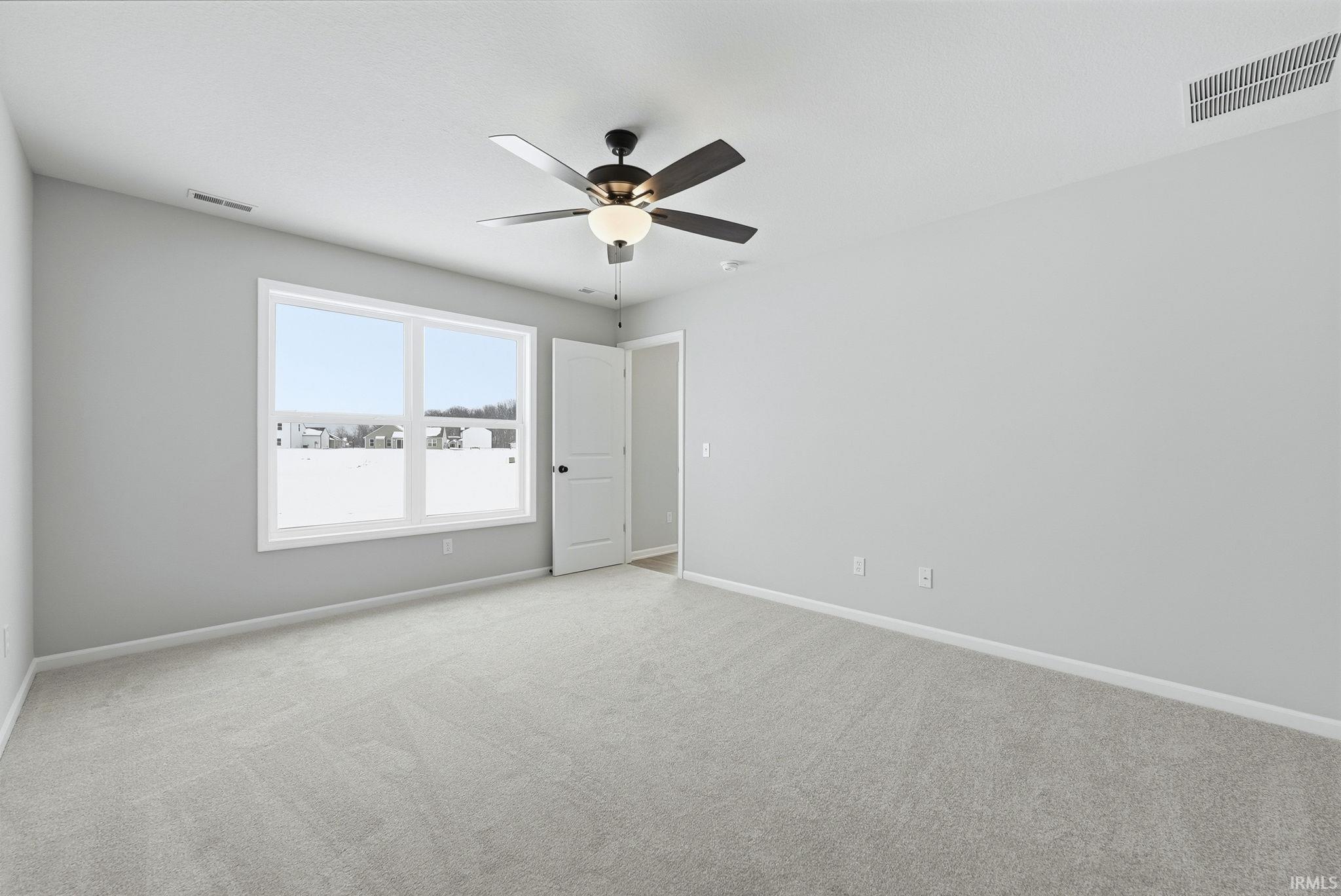 Spare room with light carpet and ceiling fan