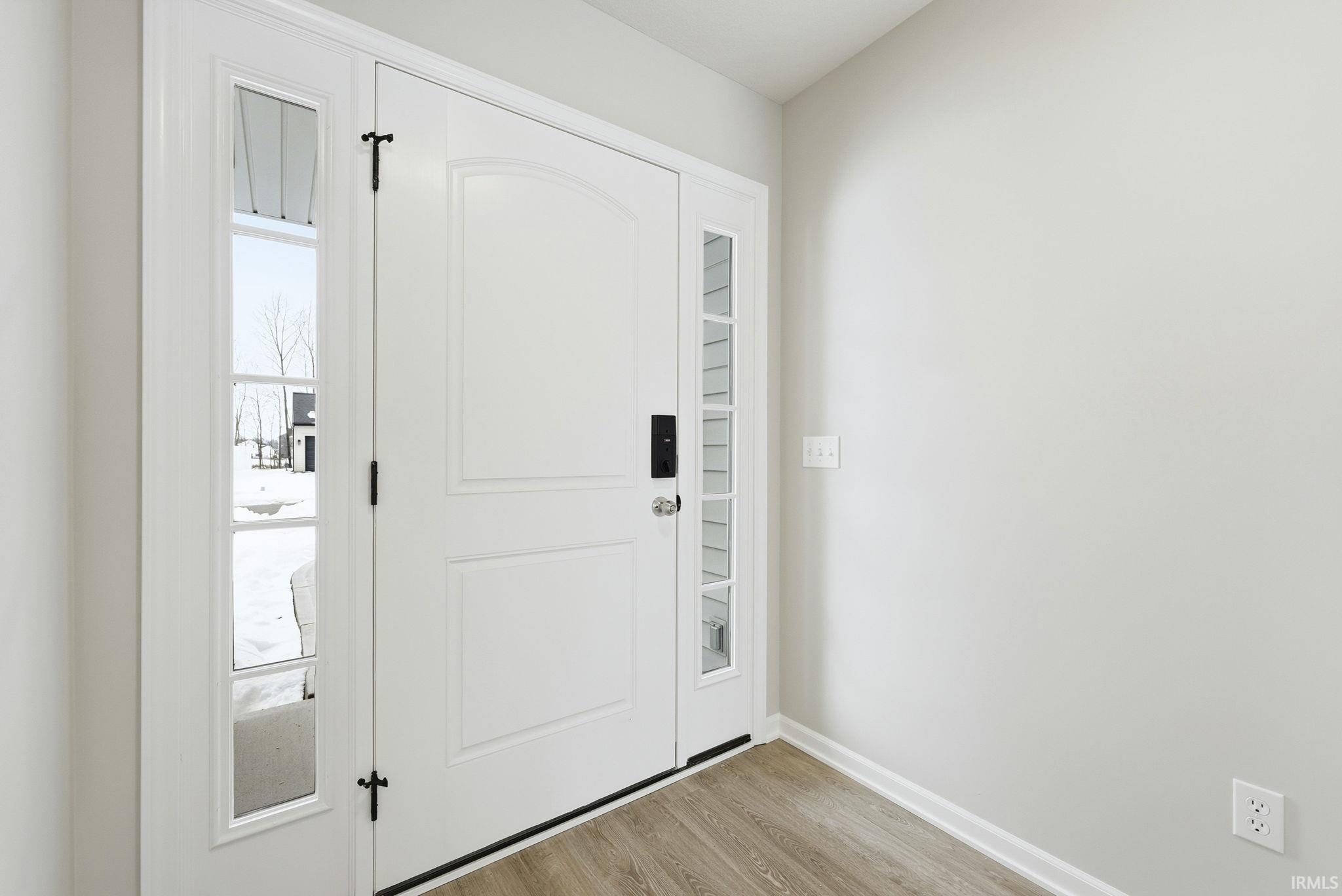 Foyer entrance featuring light wood finished floors and baseboards