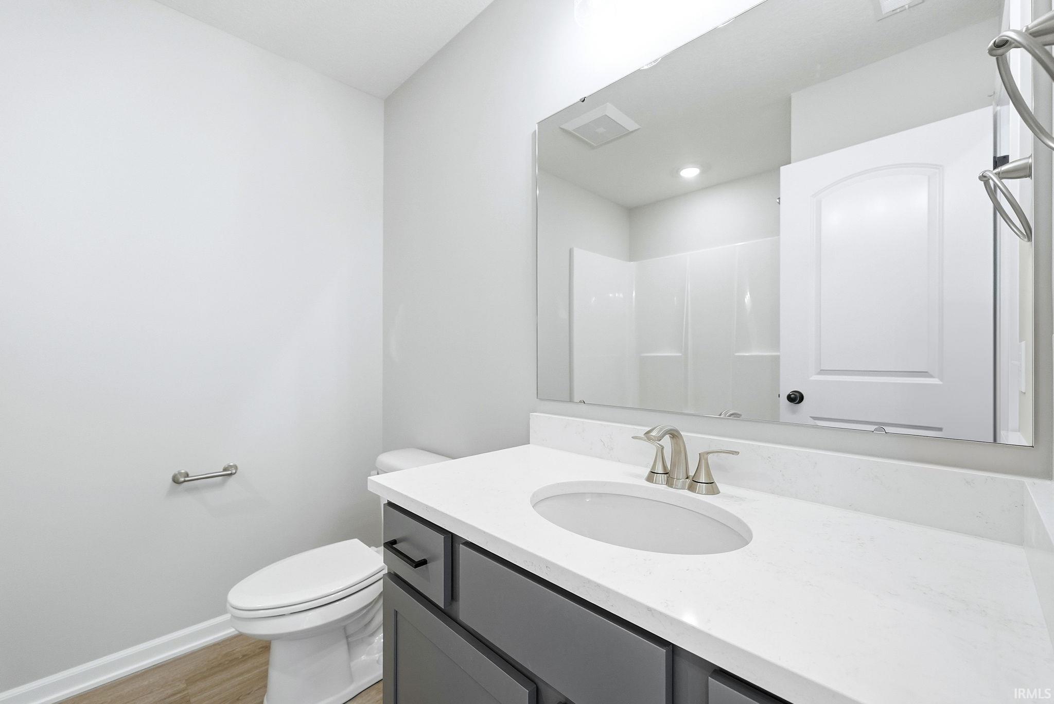 Bathroom with vanity, a shower, and light wood-style floors