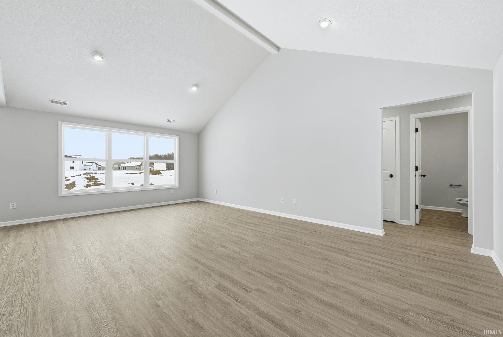 Empty room with baseboards and light wood-type flooring