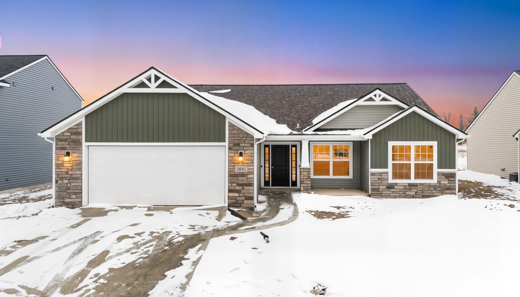 Craftsman-style house with stone siding, board and batten siding, and a garage