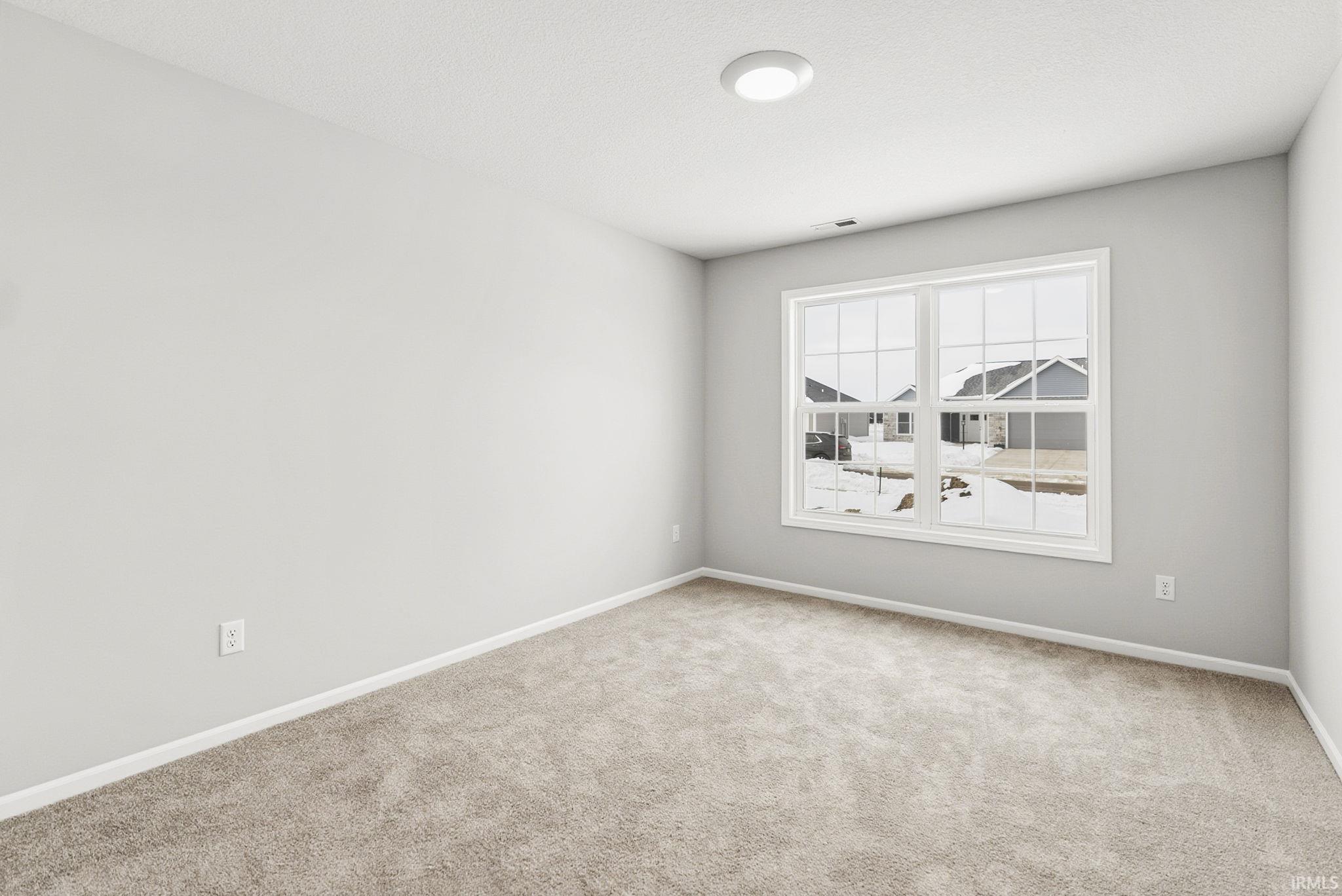 Spare room featuring baseboards and carpet flooring