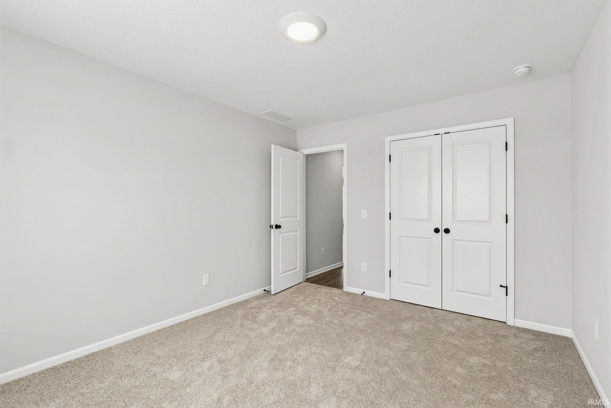 Unfurnished bedroom featuring carpet and a closet