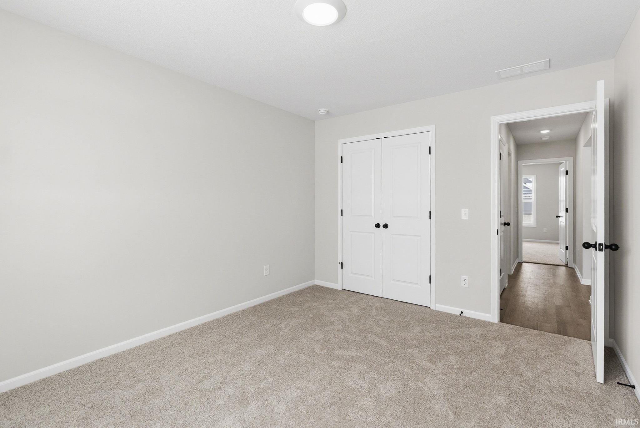 Unfurnished bedroom featuring carpet flooring and a closet