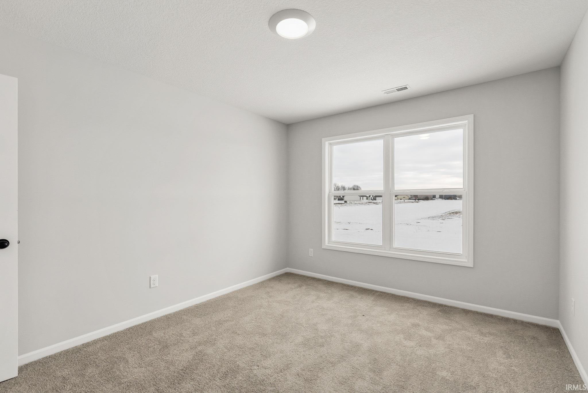 Unfurnished room with baseboards and light colored carpet