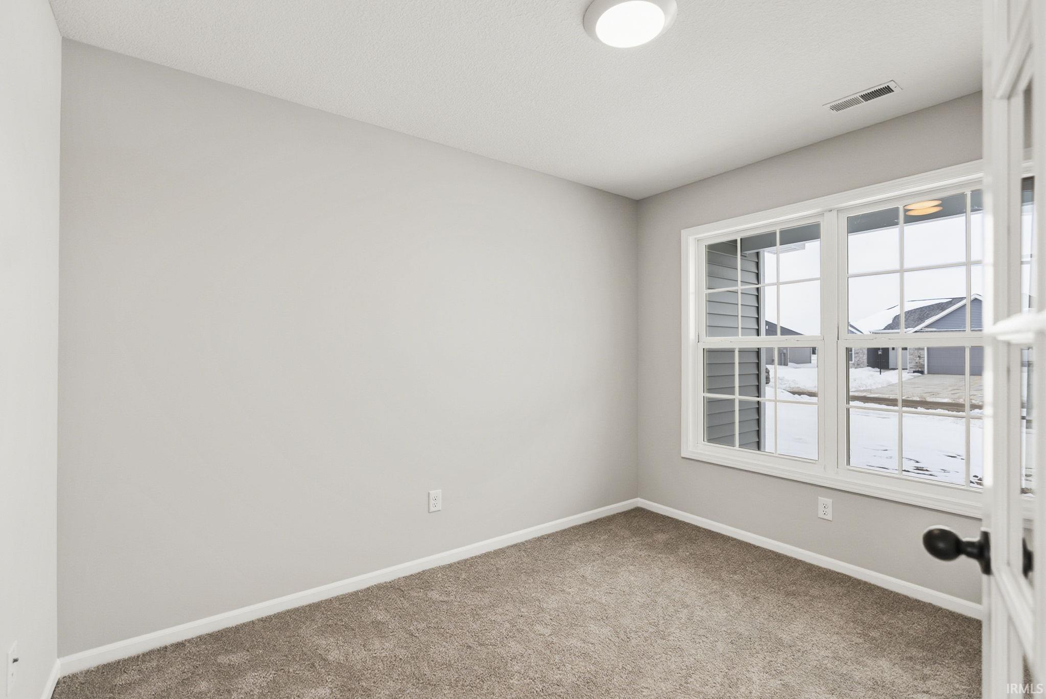 Spare room featuring baseboards and light colored carpet