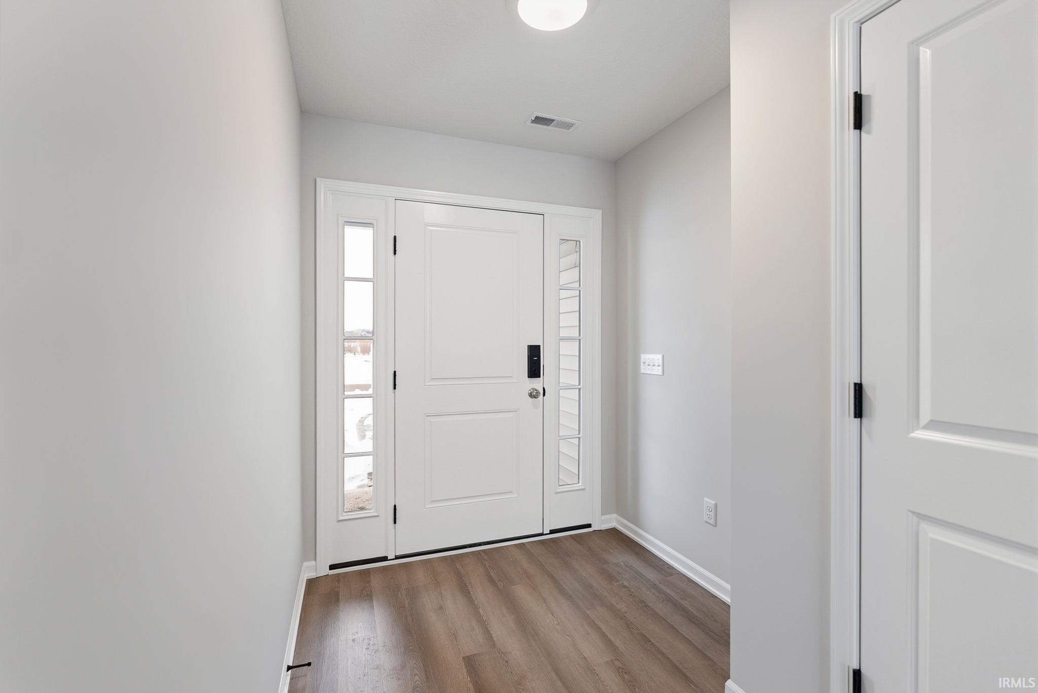 Foyer entrance featuring light wood finished floors and baseboards
