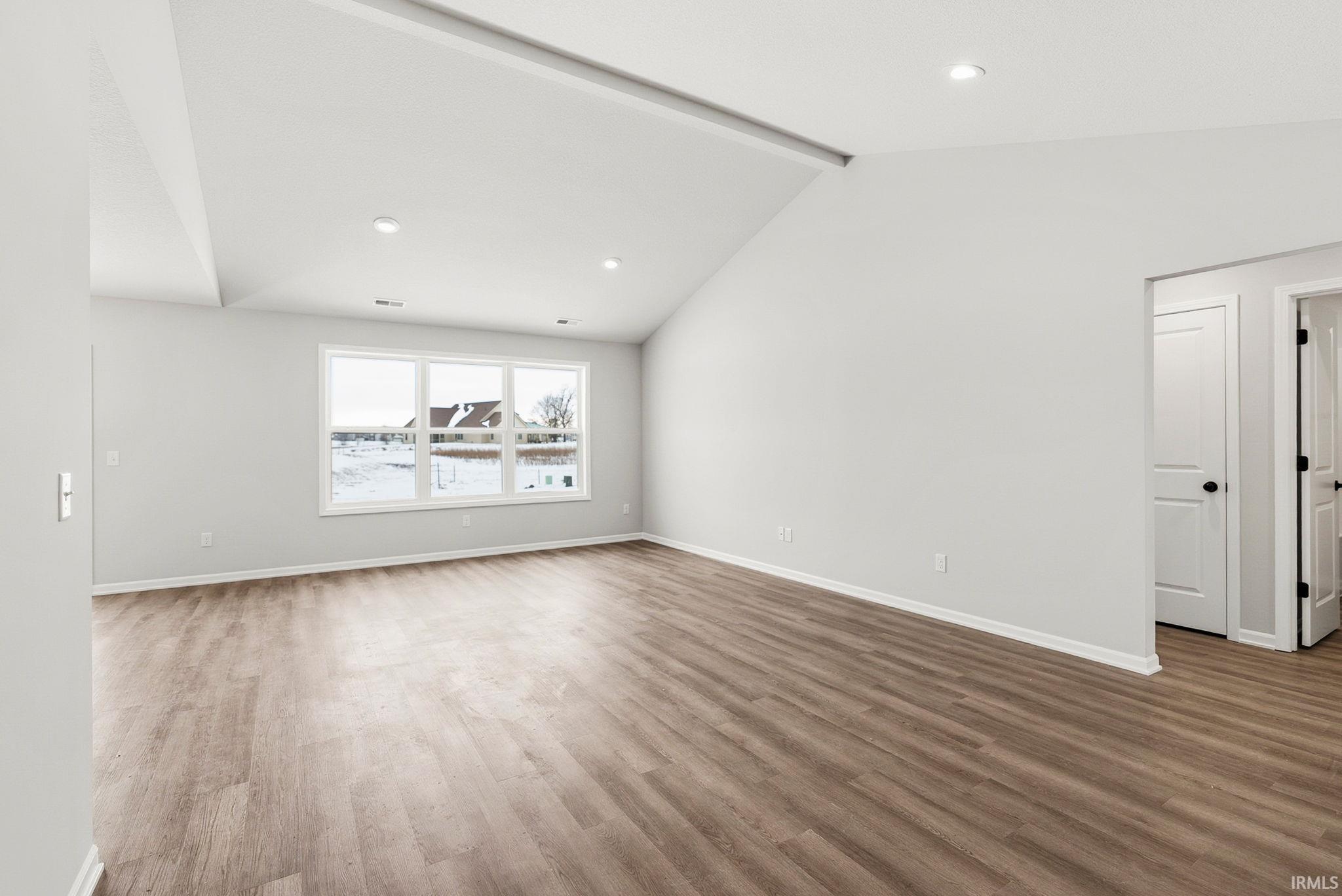 Spare room with beam ceiling, wood finished floors, and recessed lighting