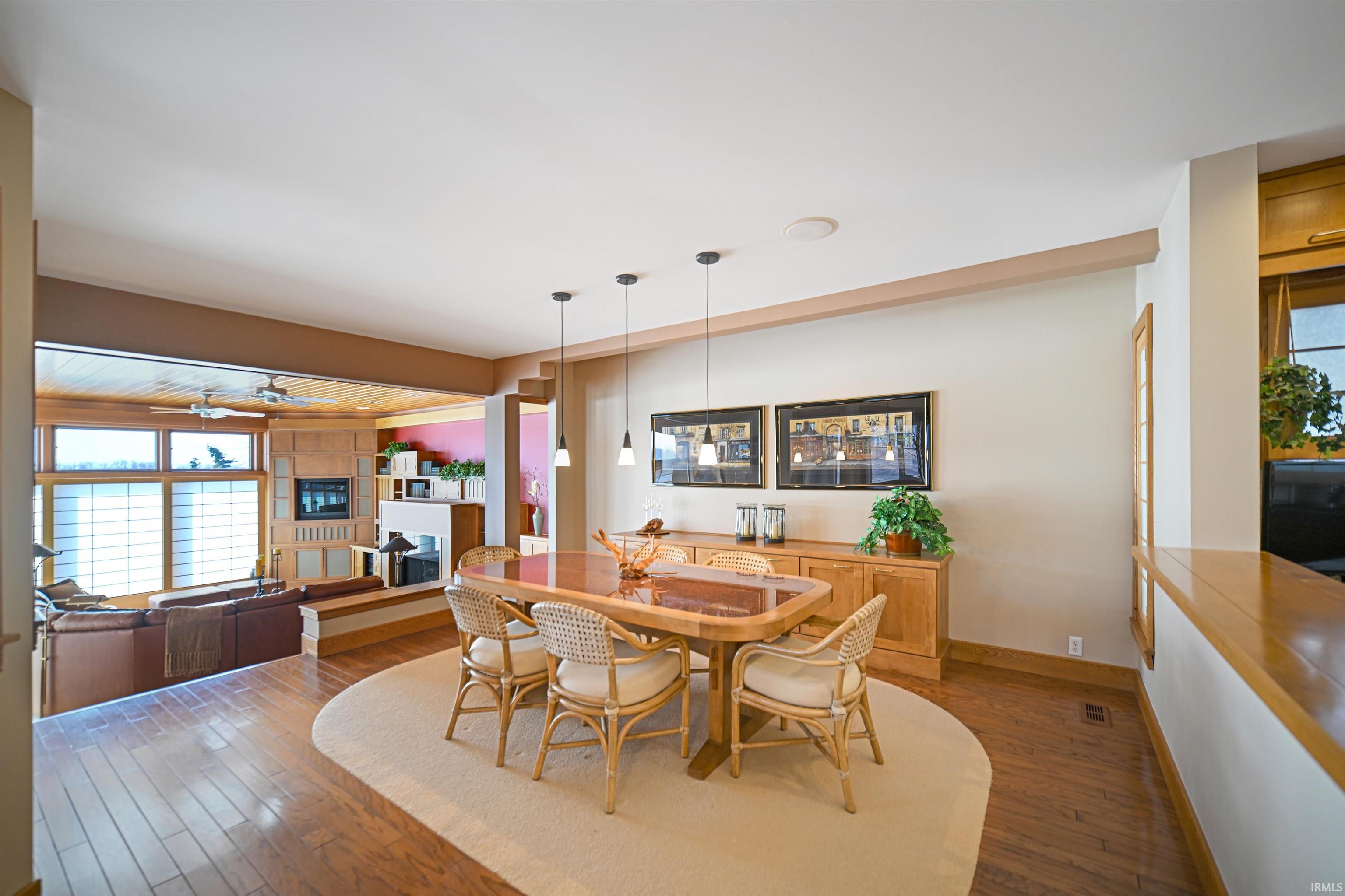 Dining area featuring hardwood / wood-style floors, a fireplace, and a ceiling fan