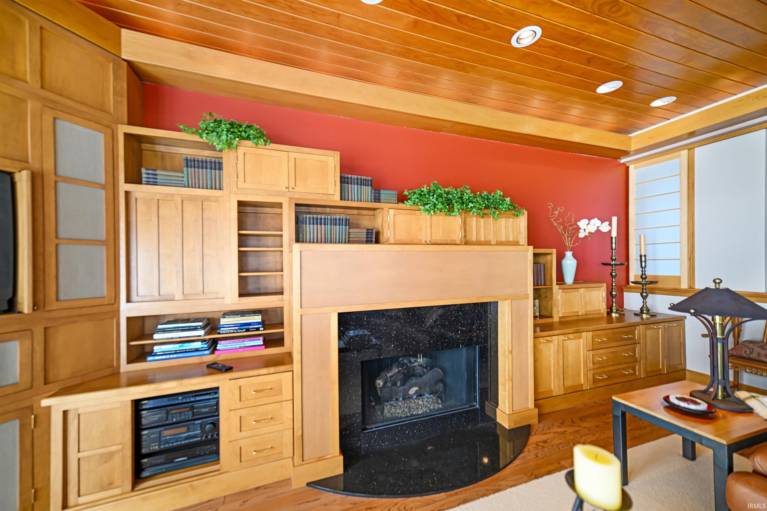 Living room with wood ceiling, a high end fireplace, and wood finished floors