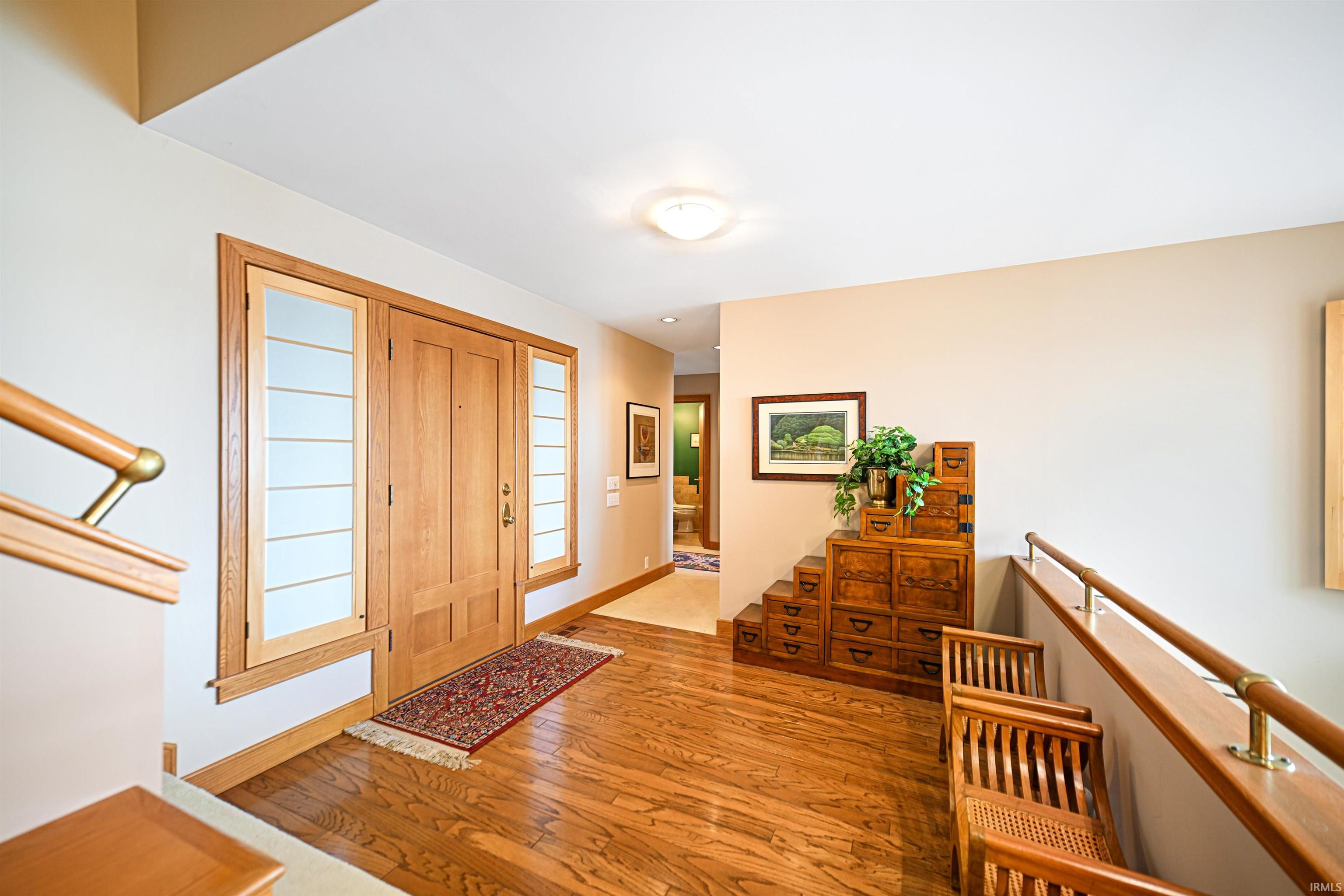 Entryway with light wood-type flooring and stairway