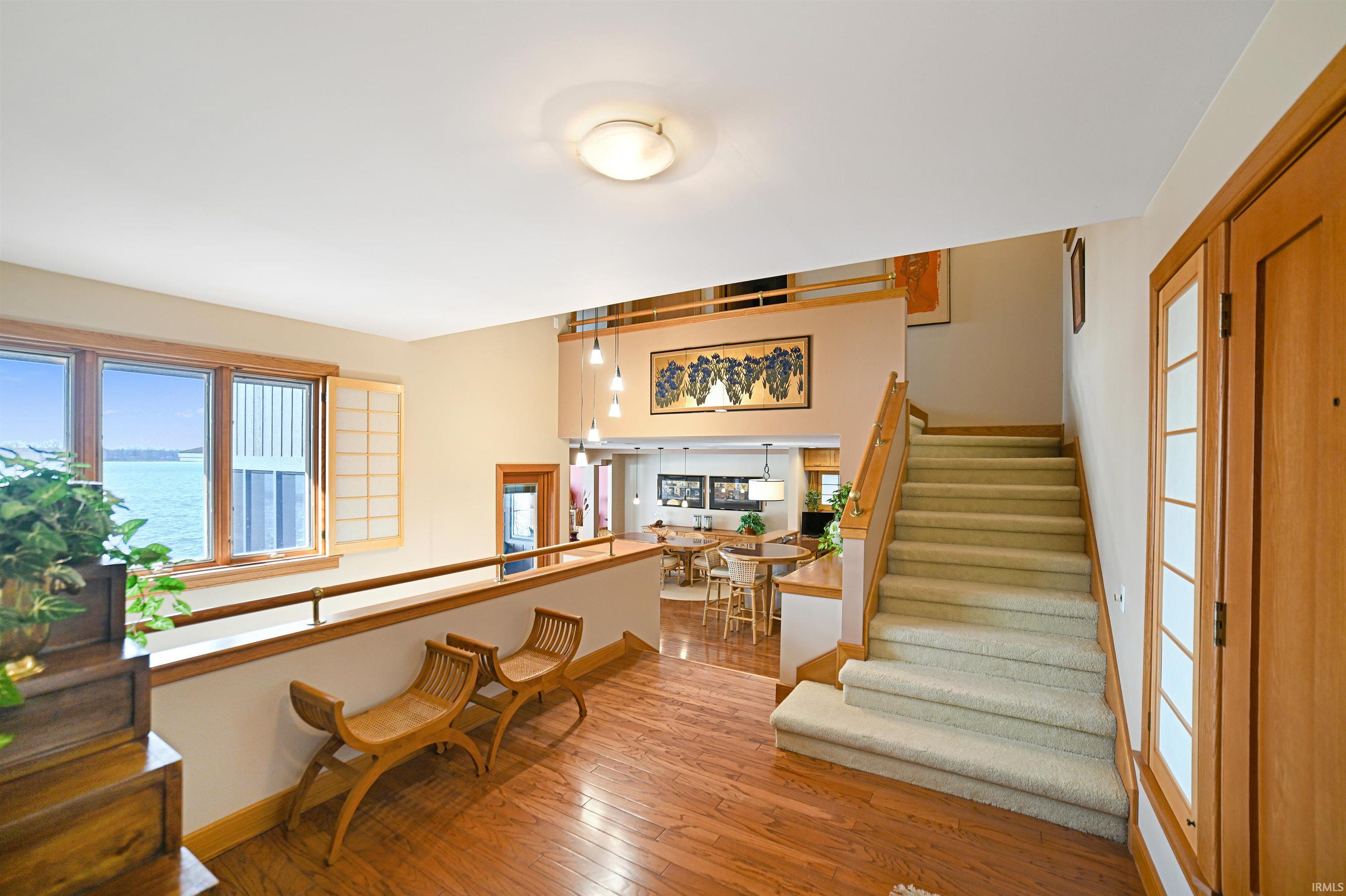 Staircase featuring hardwood / wood-style flooring and a water view