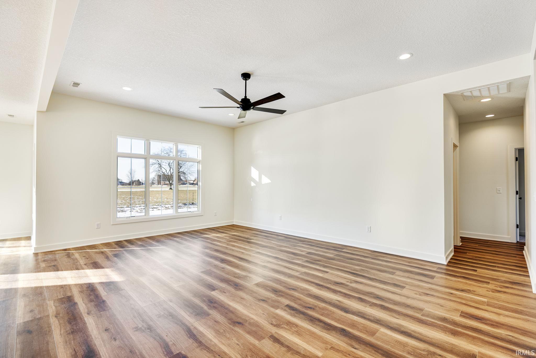Empty room featuring recessed lighting, light wood finished floors, ceiling fan, and a textured ceiling