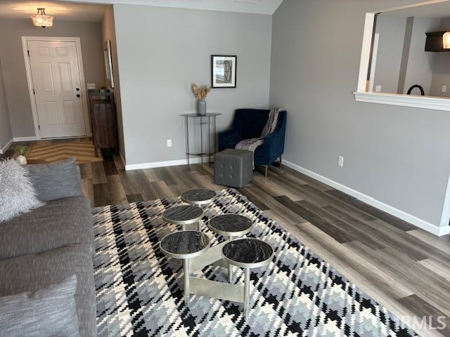 Living area with dark wood-style floors and baseboards