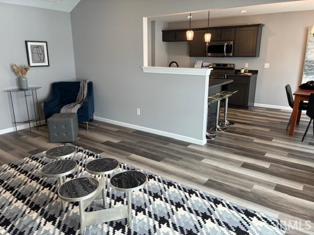 Sitting room with dark wood-type flooring and baseboards