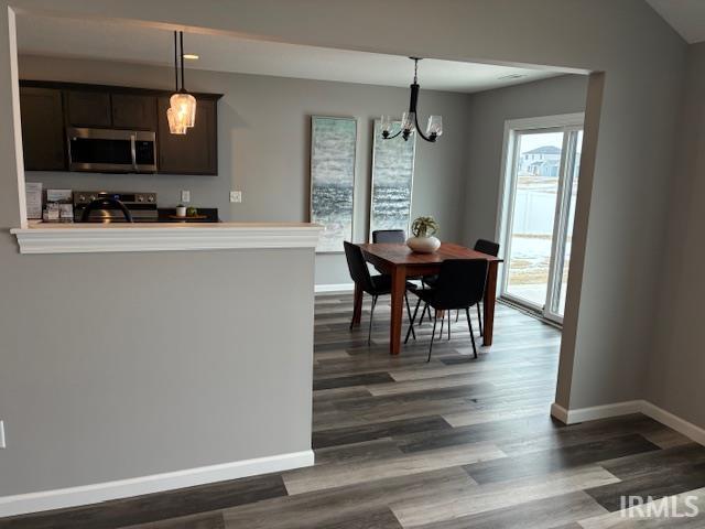 Dining room with a chandelier and dark wood-style flooring