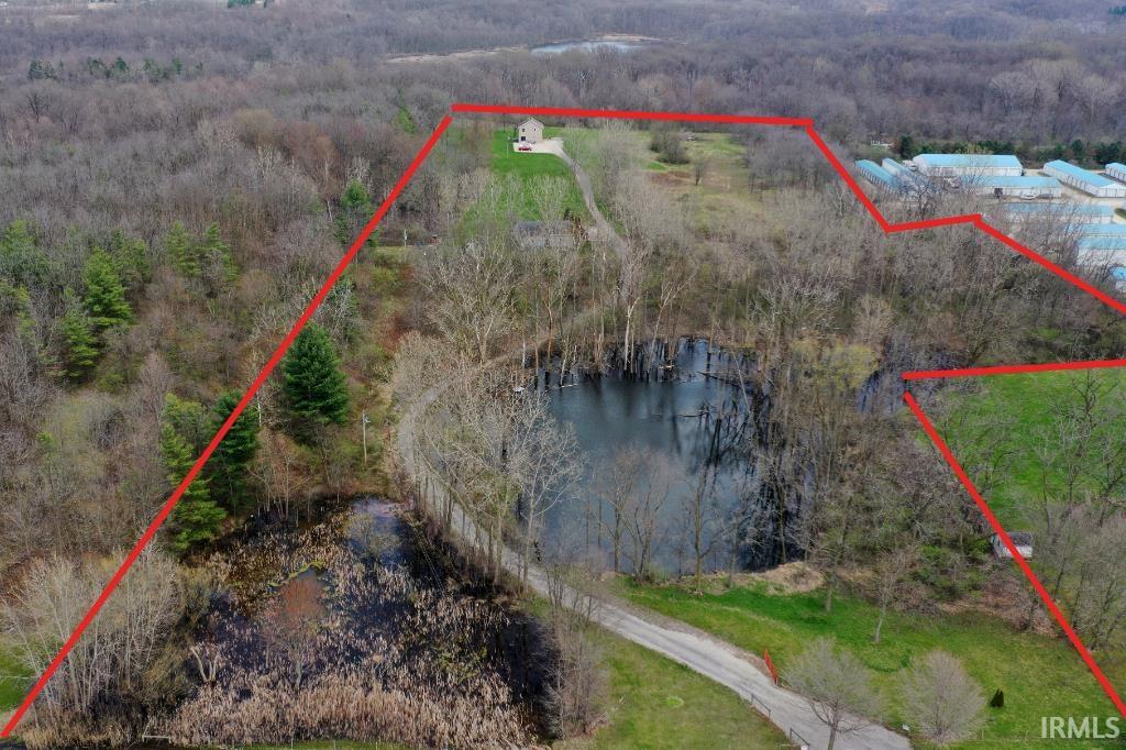Aerial view of property and surrounding area with a large body of water and property boundaries highlighted