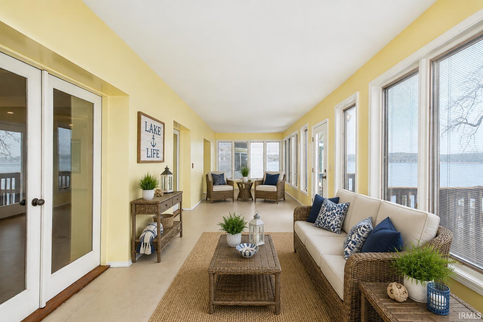Sunroom featuring a wall of floor-to-ceiling windows, light yellow walls, and a light-colored floor