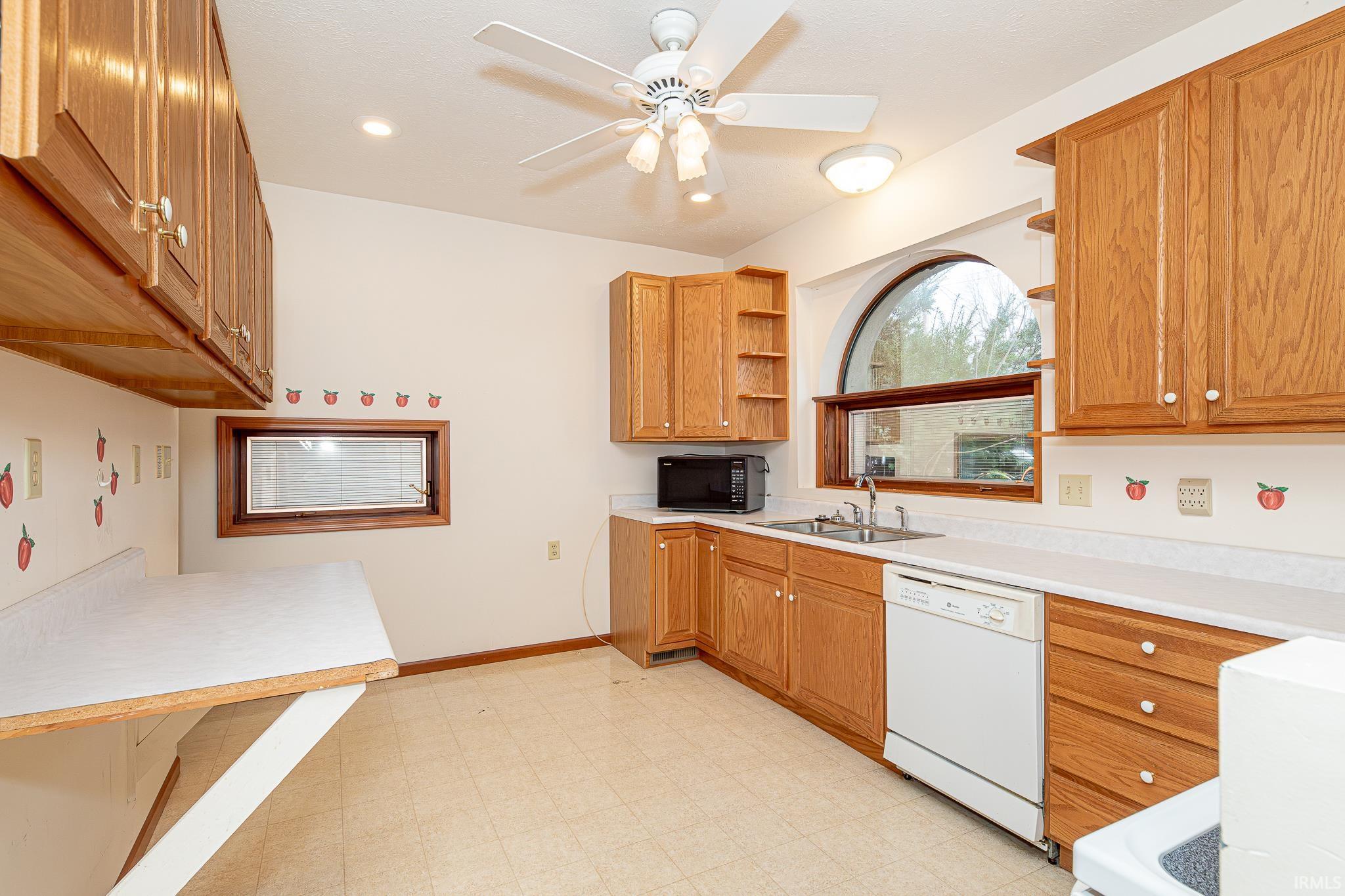 Kitchen with light floors, light countertops, open shelves, dishwasher, and recessed lighting