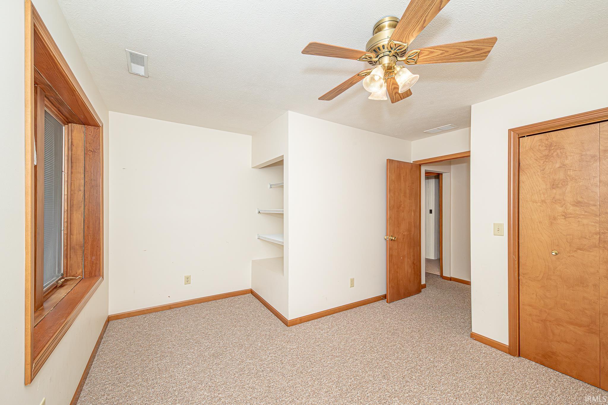 Unfurnished room with light carpet, a textured ceiling, and ceiling fan