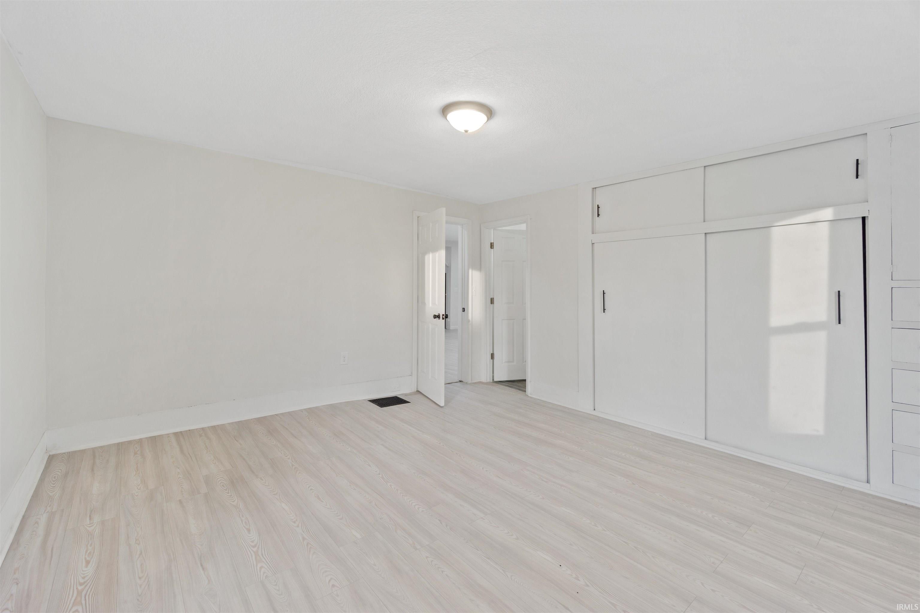 Unfurnished bedroom featuring light wood-style flooring and a closet