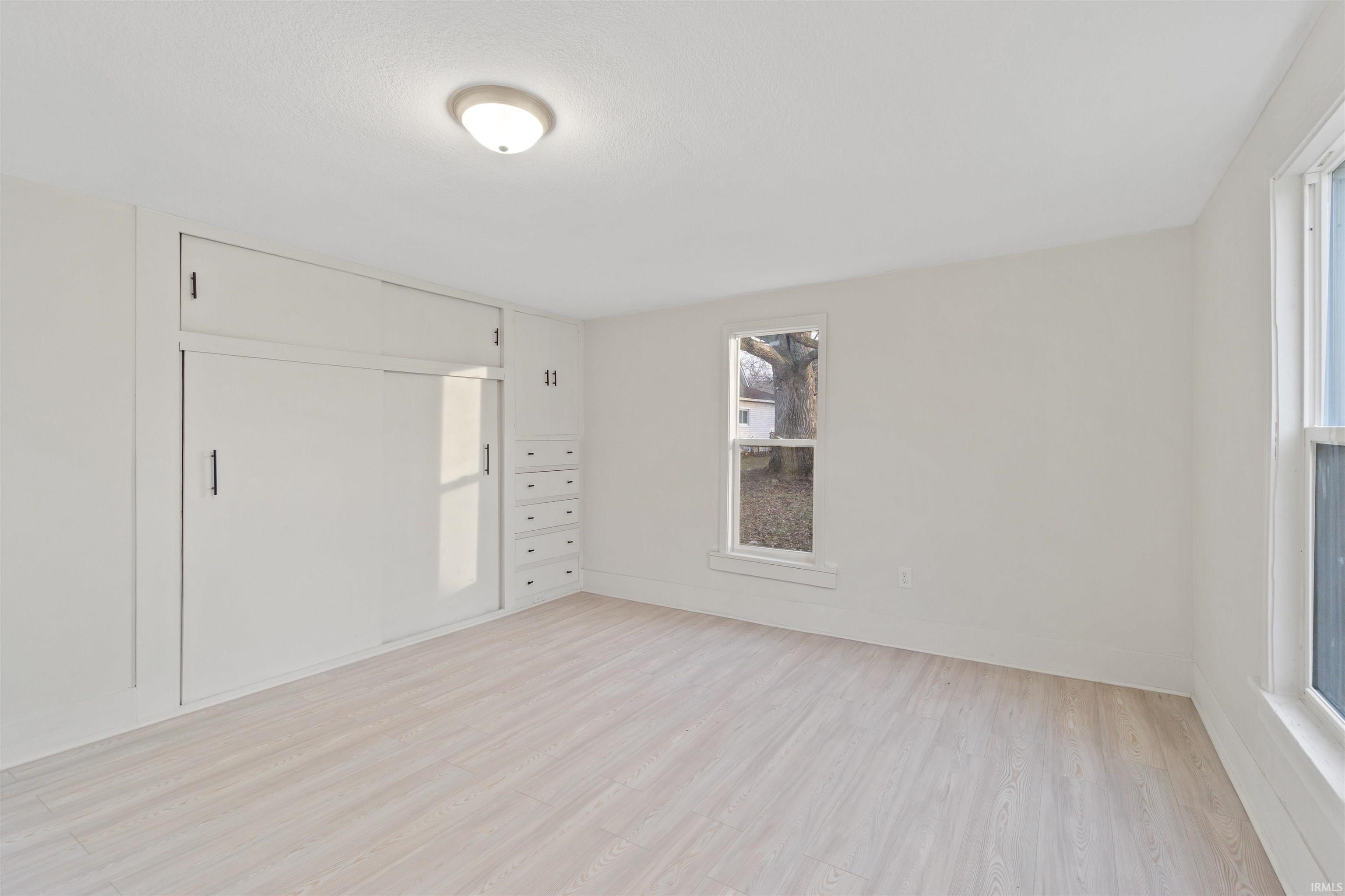 Unfurnished bedroom with a closet and light wood-style floors