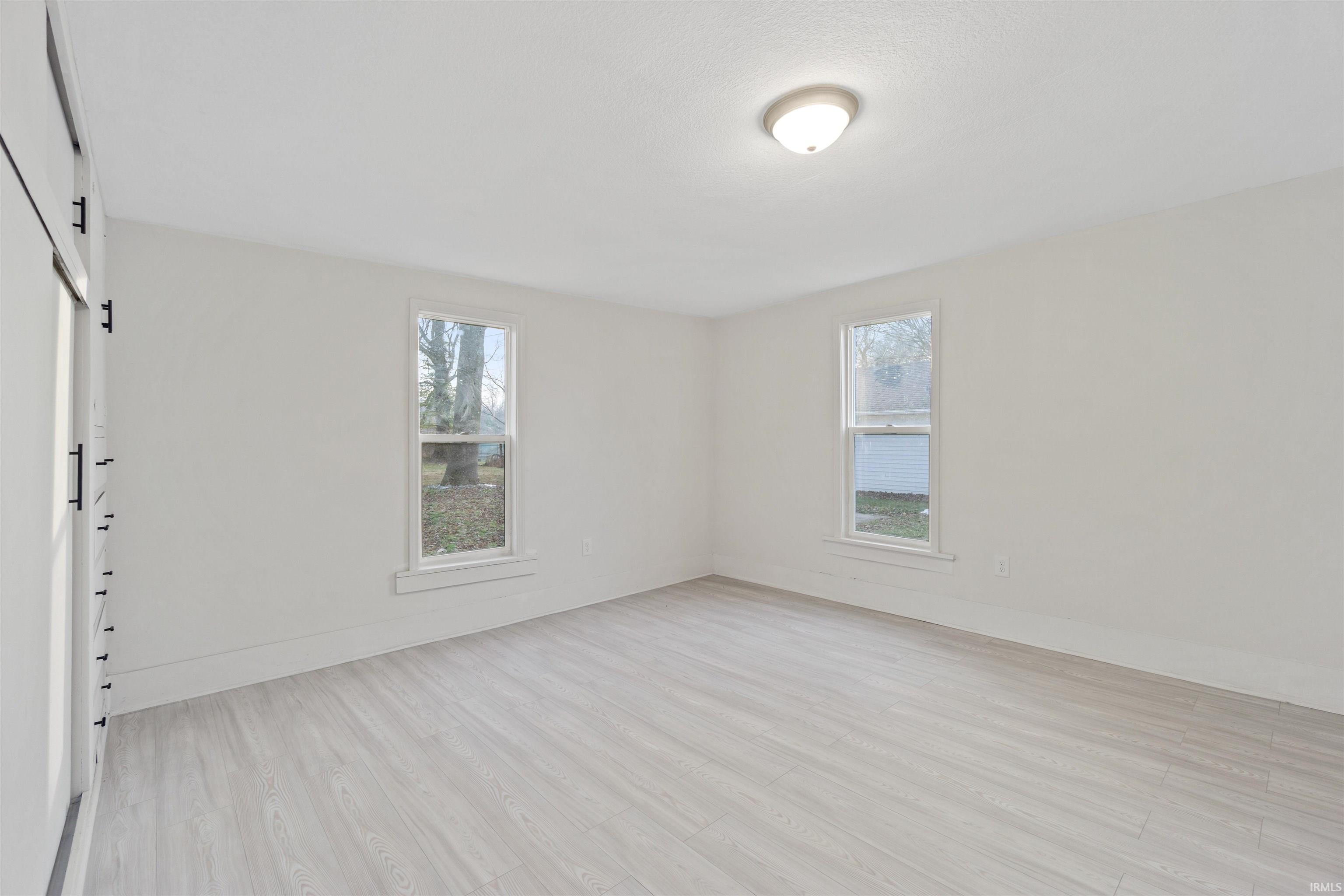 Unfurnished room with light wood-style floors and healthy amount of natural light