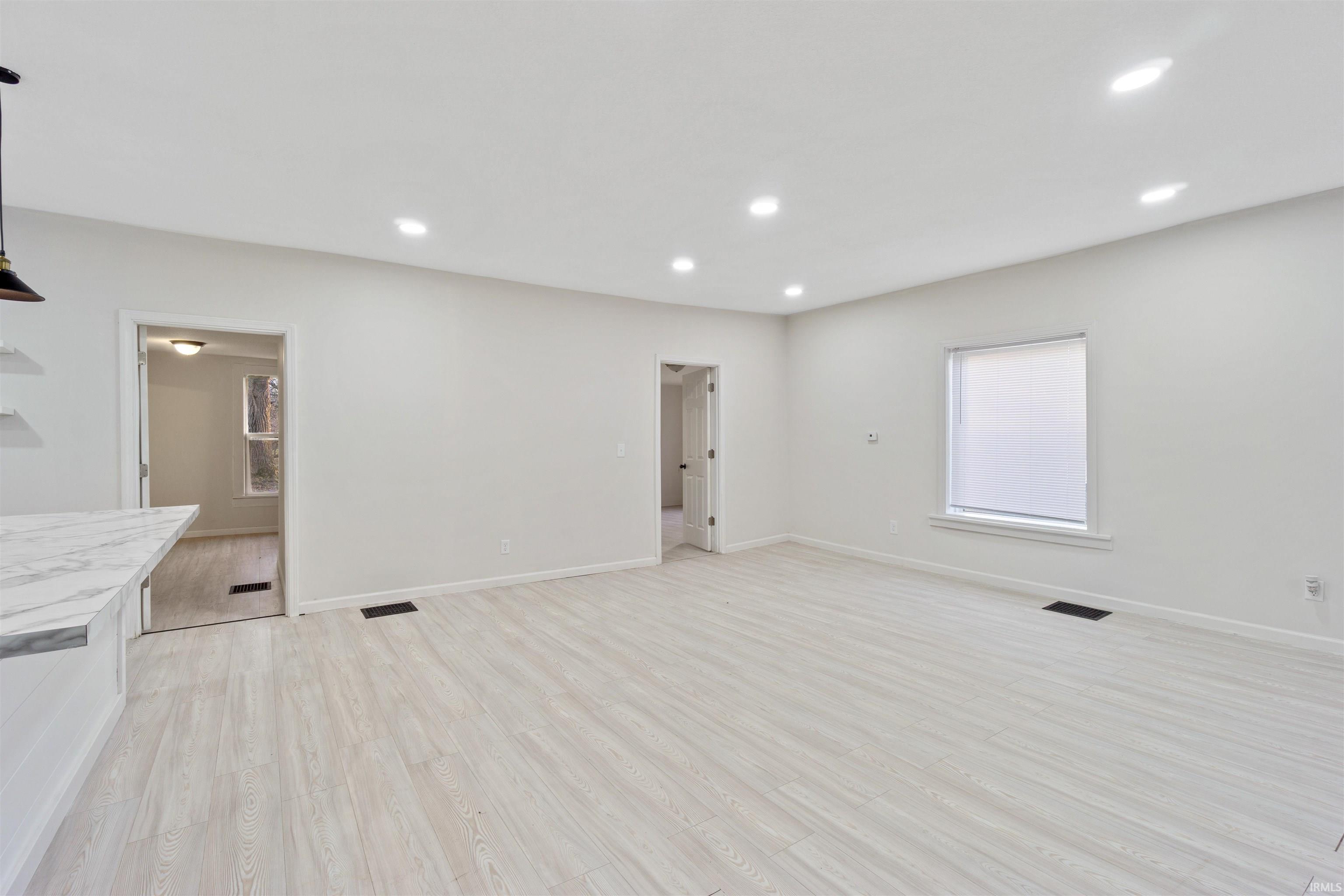 Unfurnished living room with light wood finished floors and recessed lighting