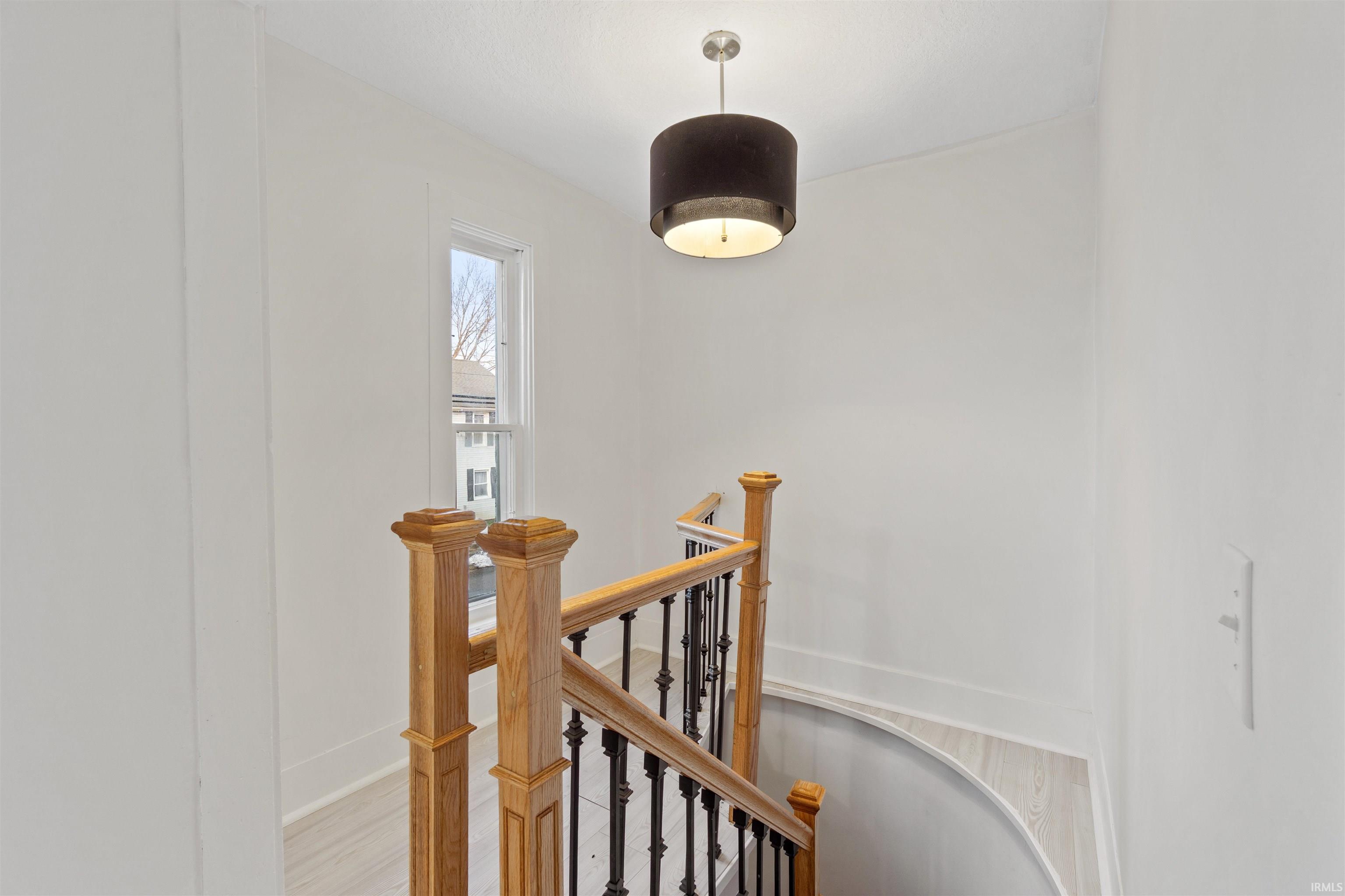 Hall featuring an upstairs landing and light wood-type flooring