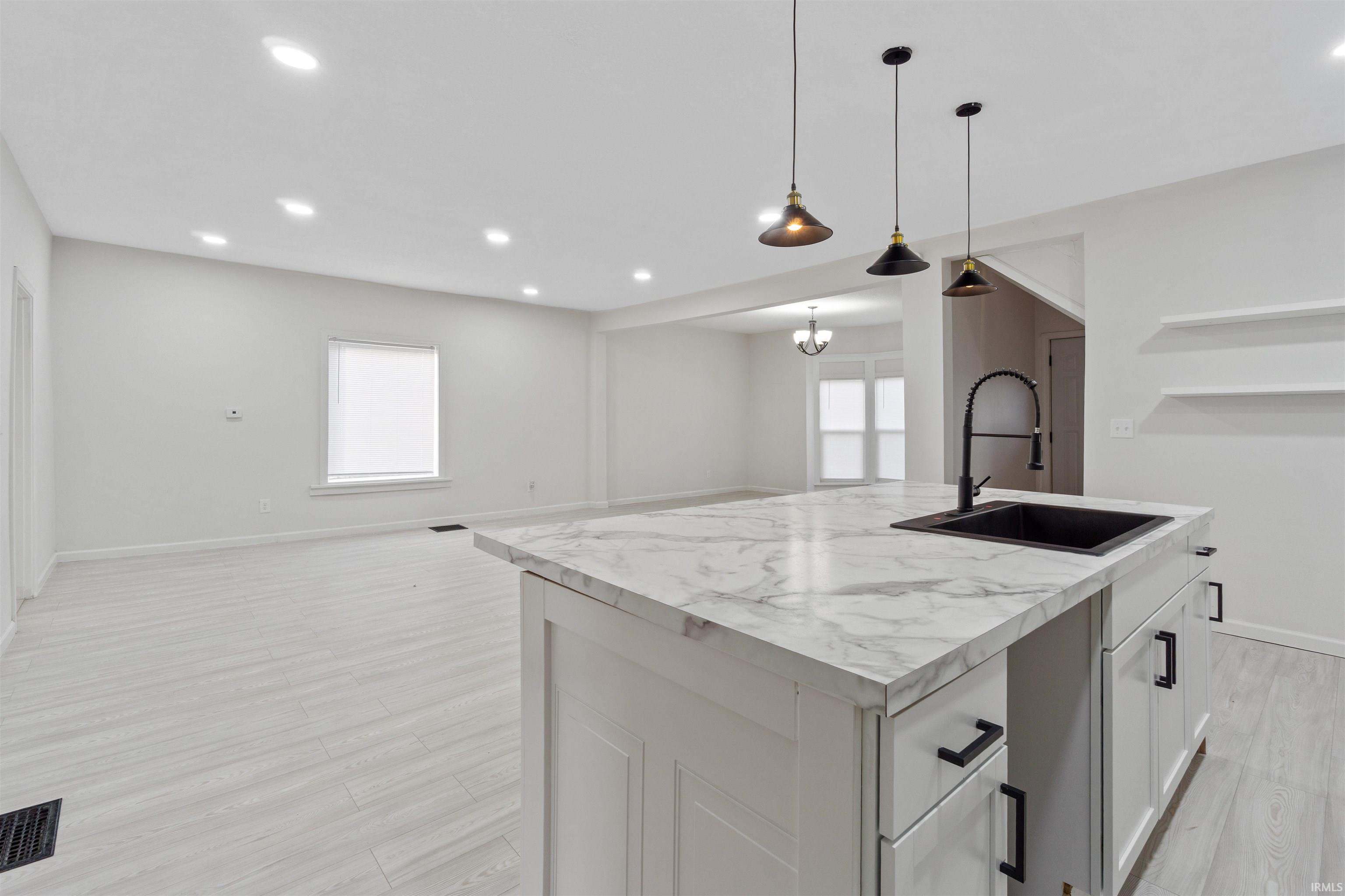 Kitchen with open floor plan, plenty of natural light, pendant lighting, a center island with sink, and recessed lighting