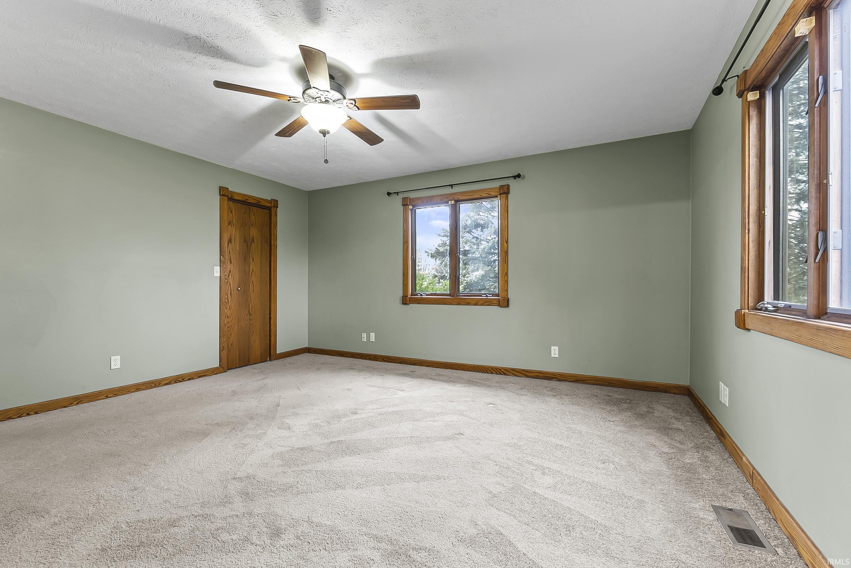 Unfurnished room featuring light carpet and a ceiling fan