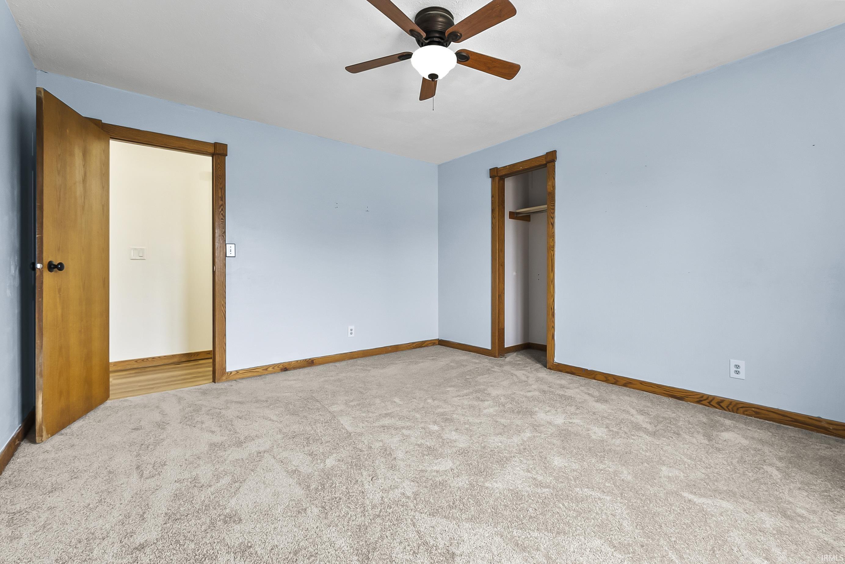 Unfurnished bedroom featuring light carpet, a closet, and ceiling fan