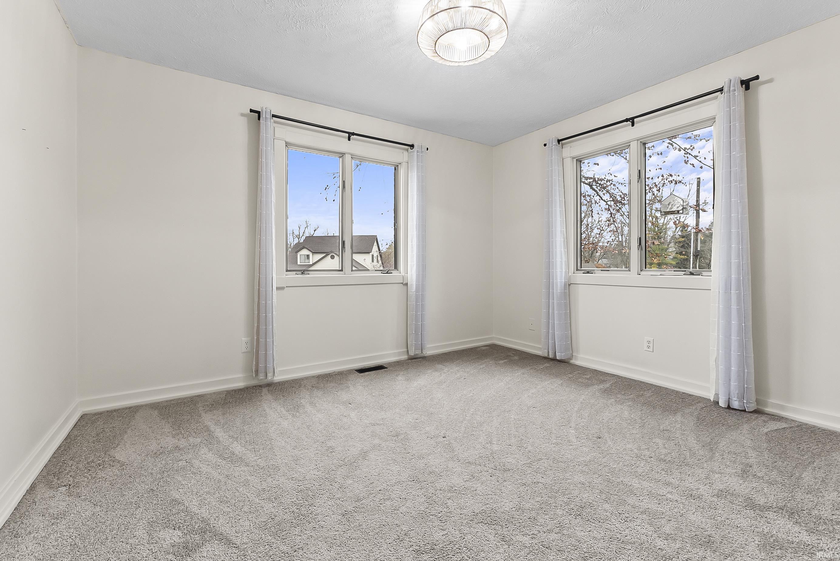 Empty room with plenty of natural light and light carpet