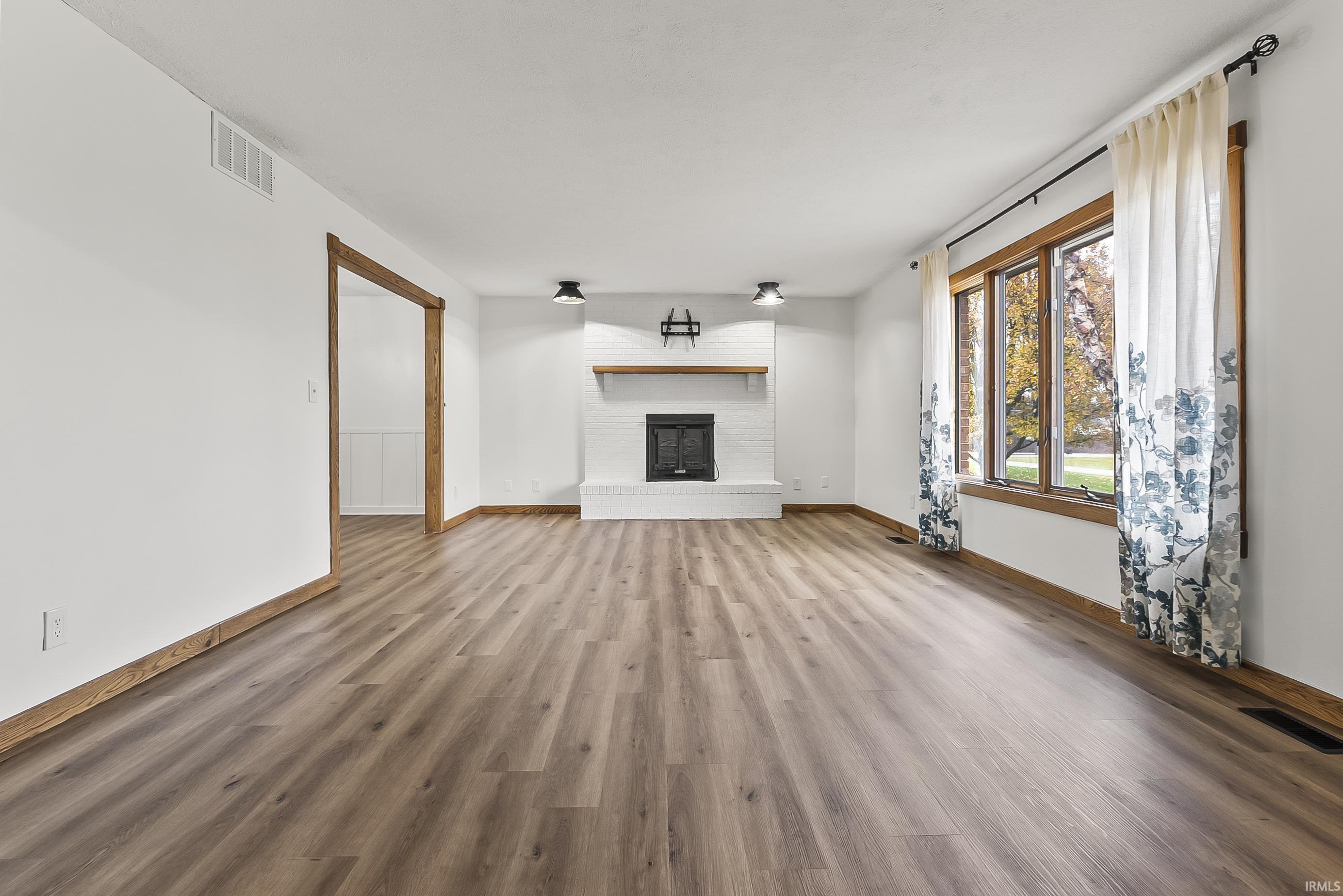 Unfurnished living room with wood finished floors and a fireplace