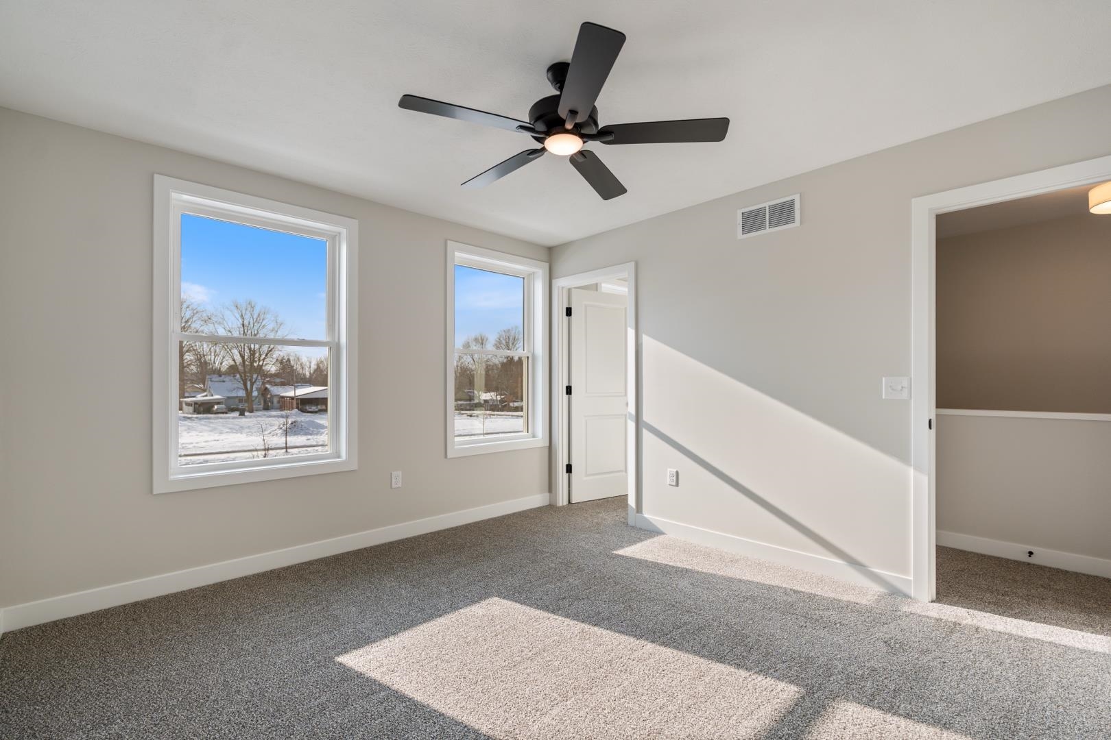 Carpeted spare room with baseboards and ceiling fan