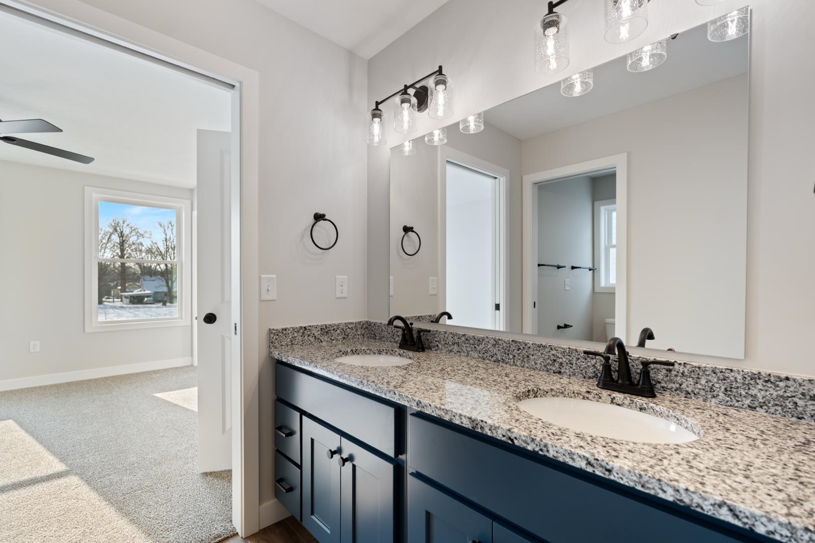 Full bathroom featuring double vanity and dark colored carpet