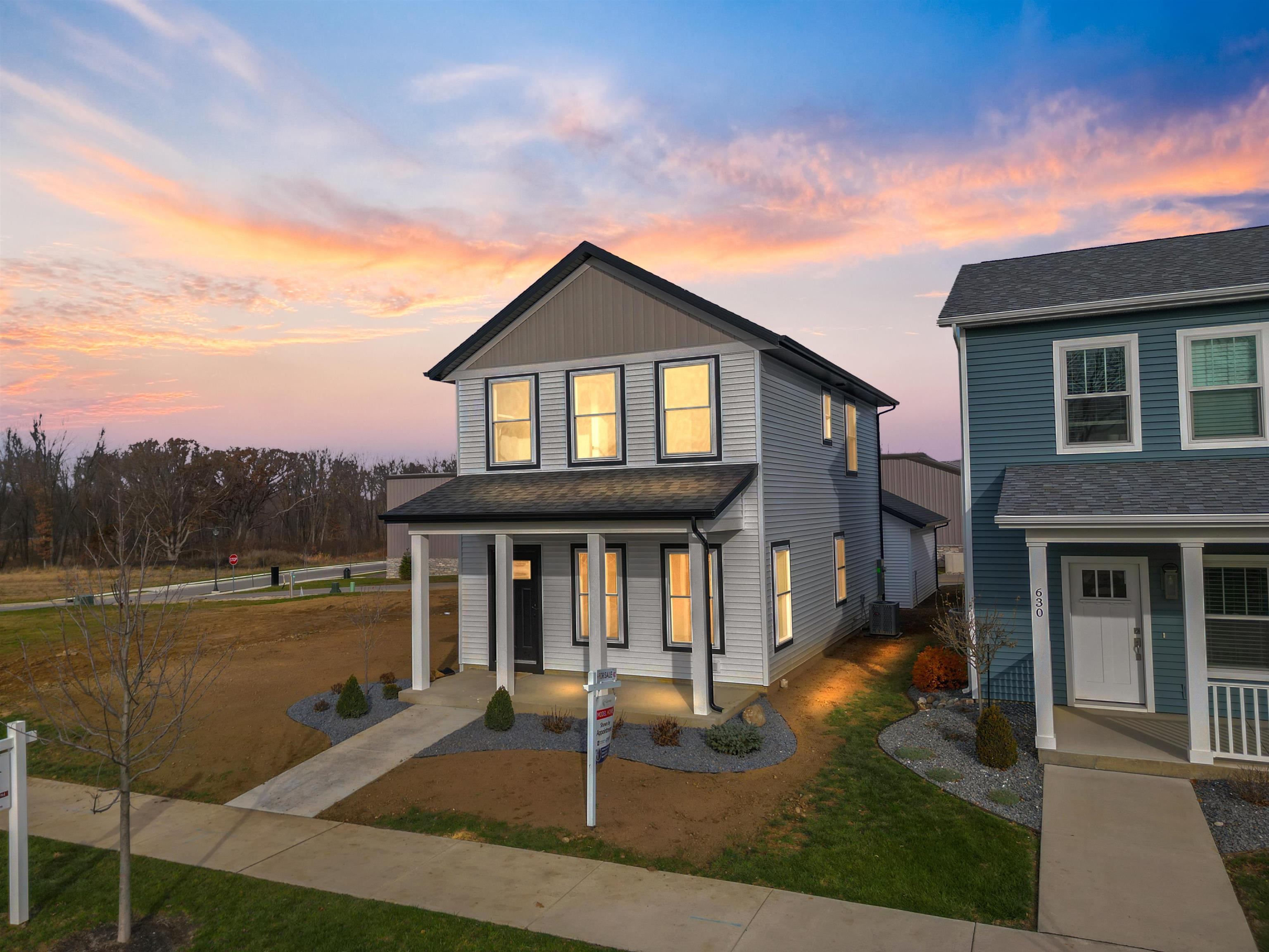 View of front of home featuring covered porch and a lawn