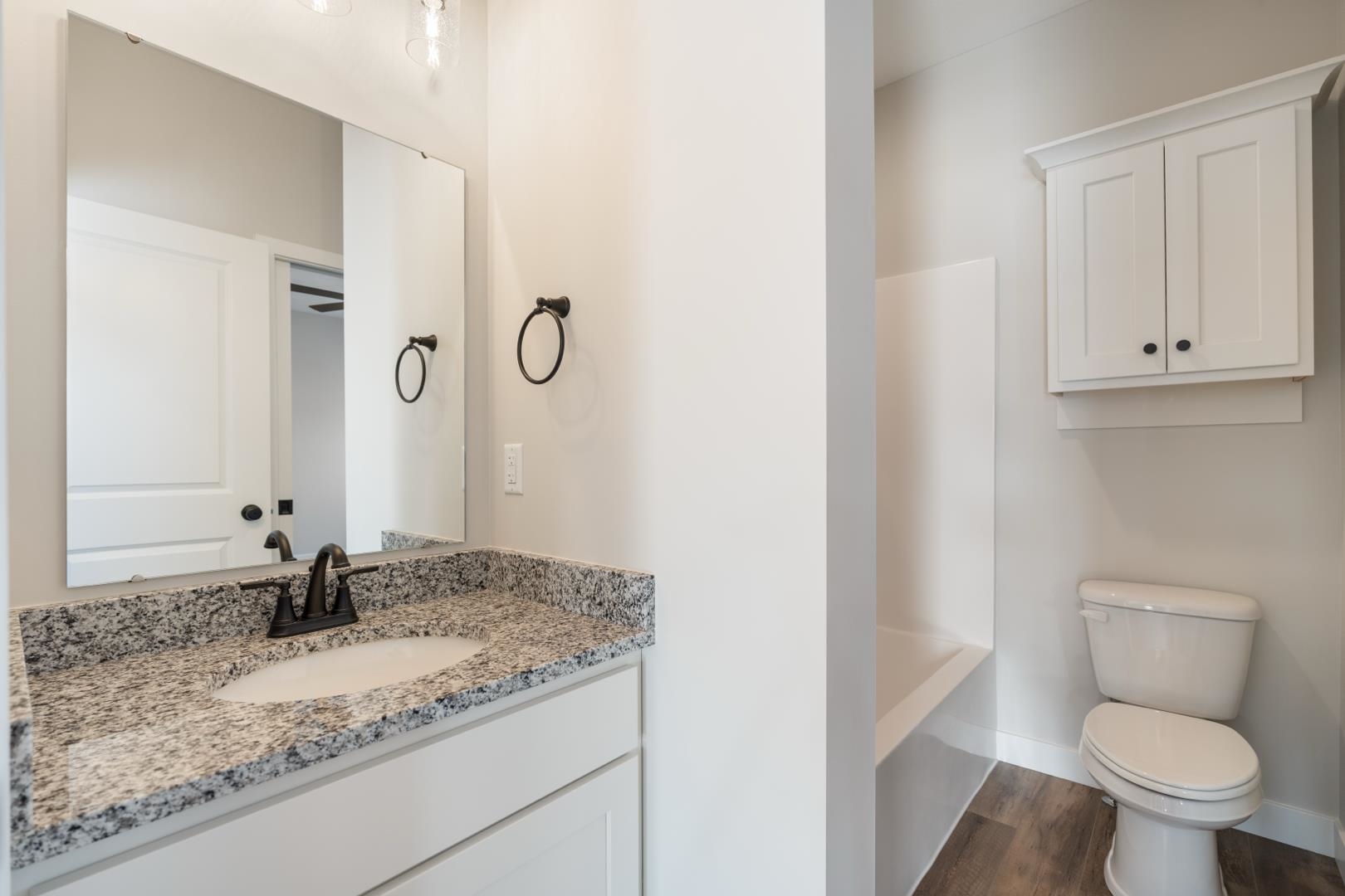 Full bath with vanity, dark wood finished floors, and shower / tub combination